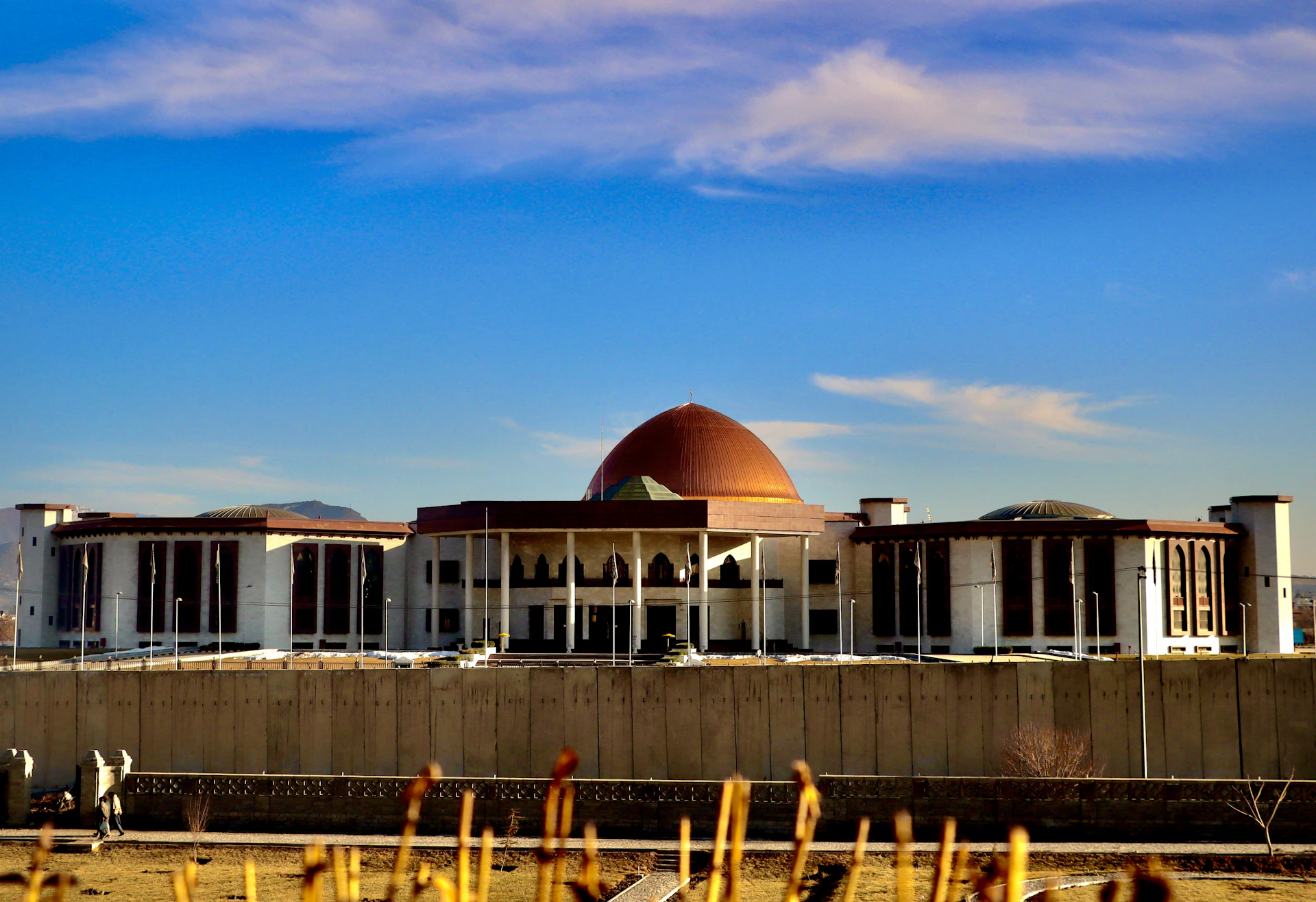 Modern building with a large dome under blue sky.