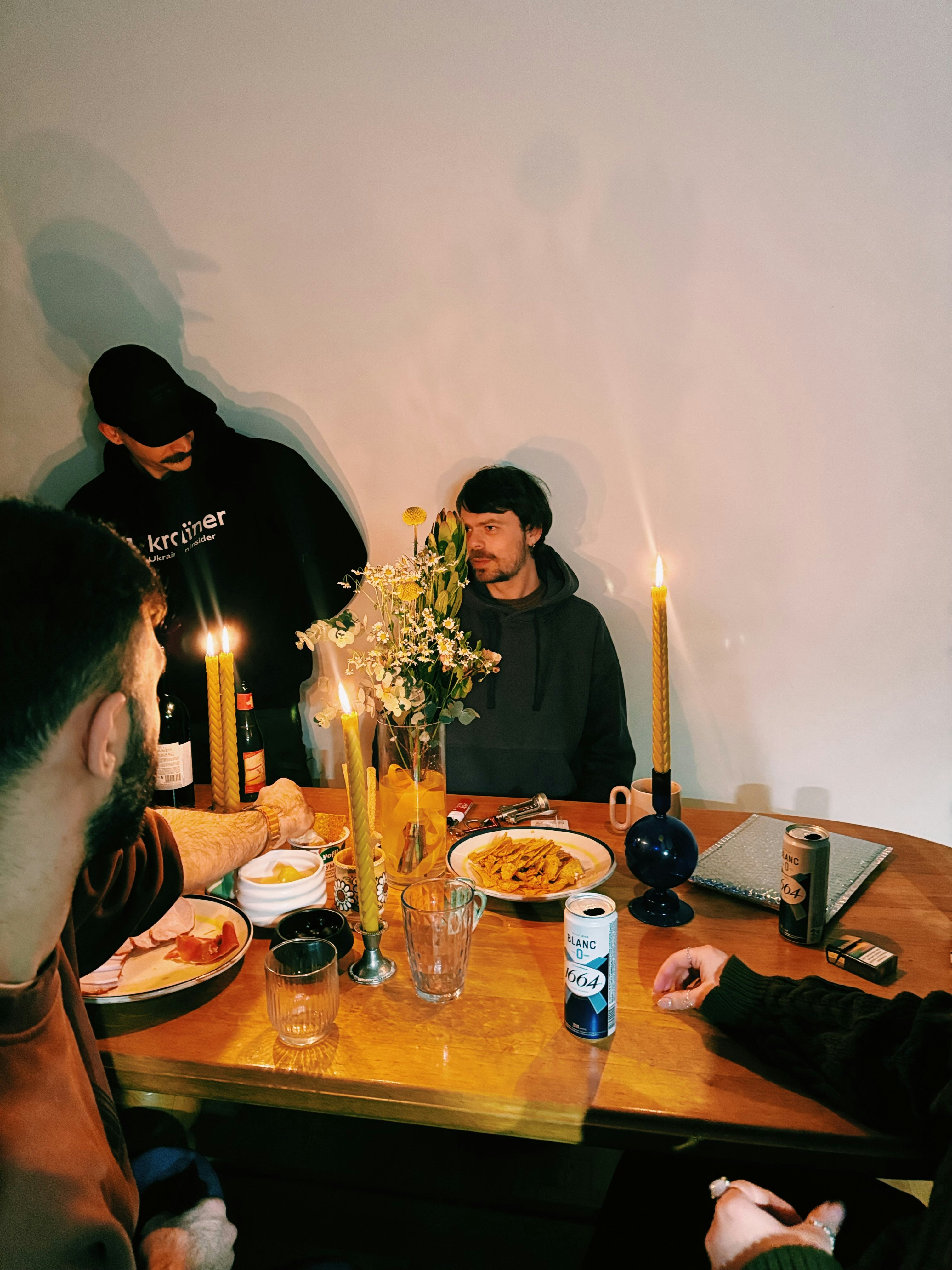 Friends gathered around a table with food and candles