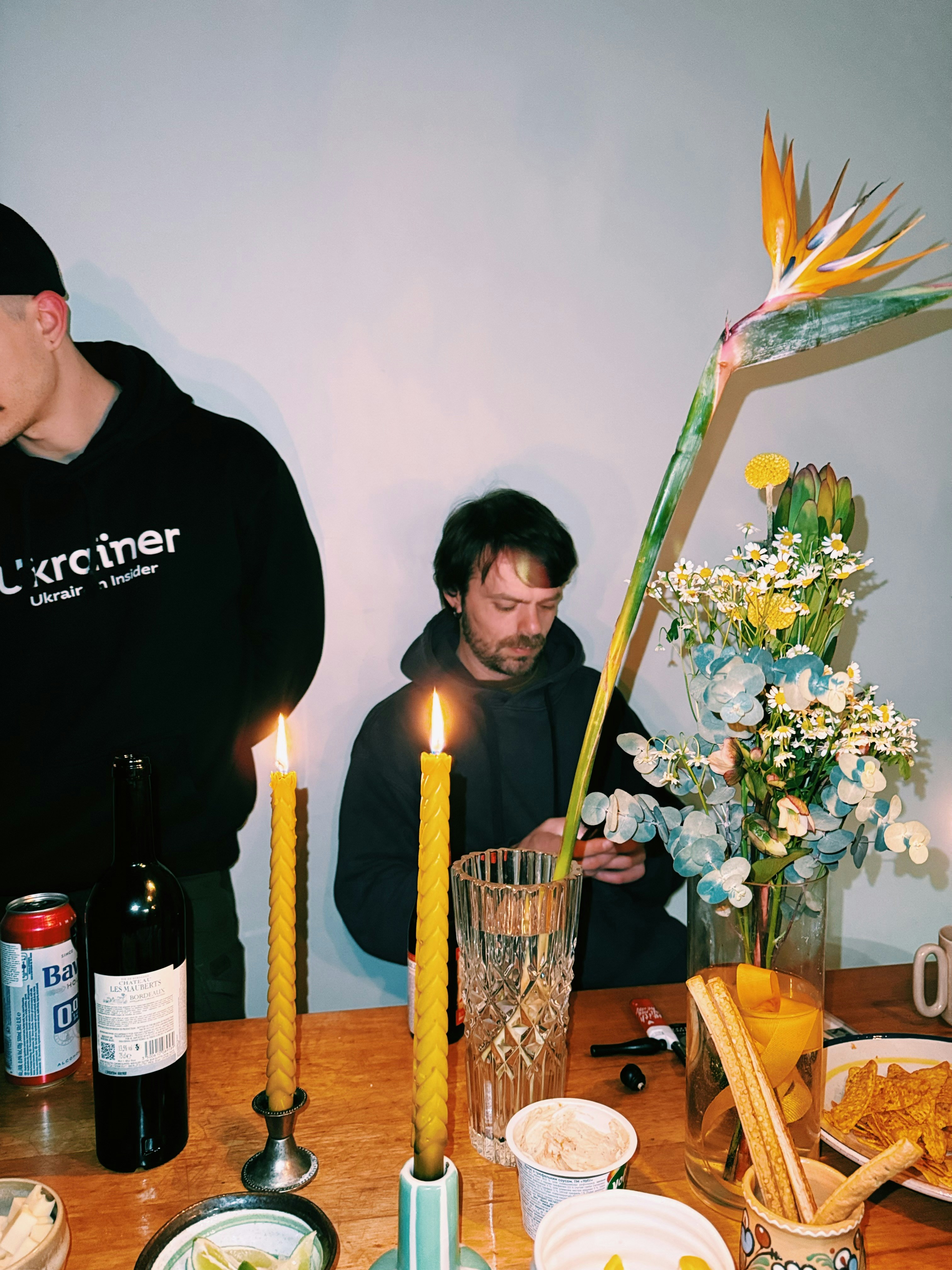 Die Menschen versammelten sich um einen Tisch mit Kerzen und Blumen.