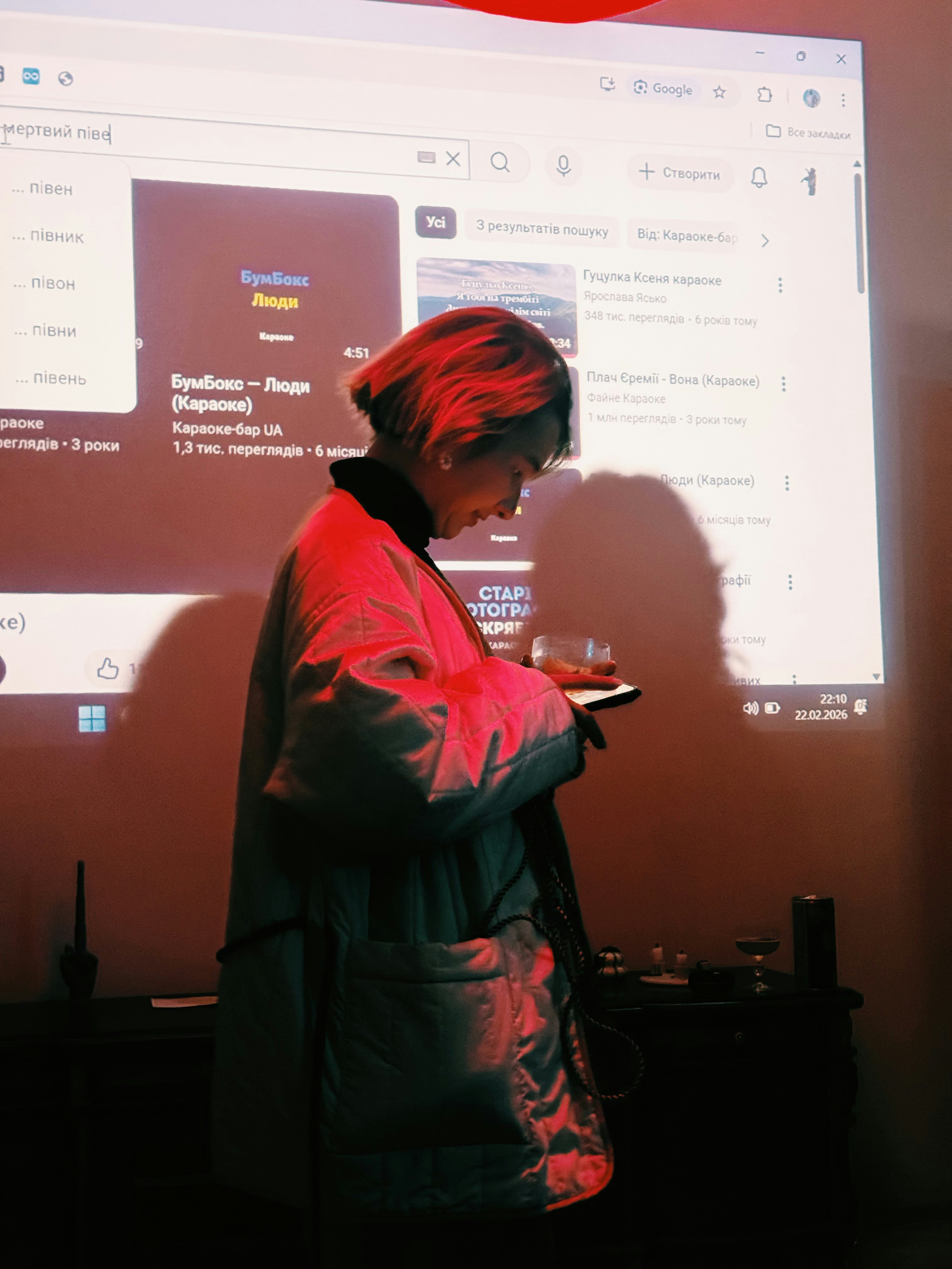 Frau im leichten Mantel, die ein Glas hält