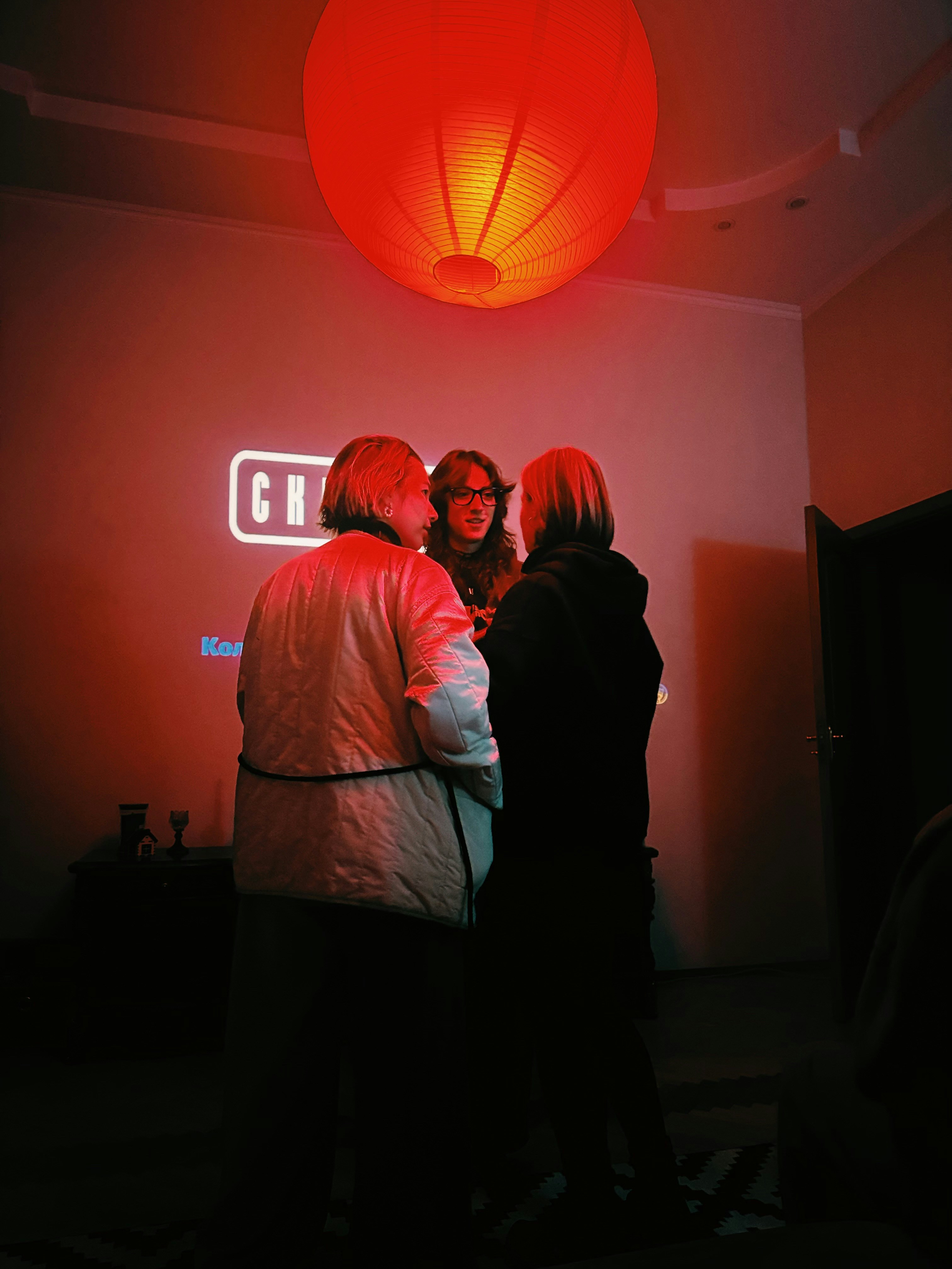 Drei Leute reden unter einer roten Laterne