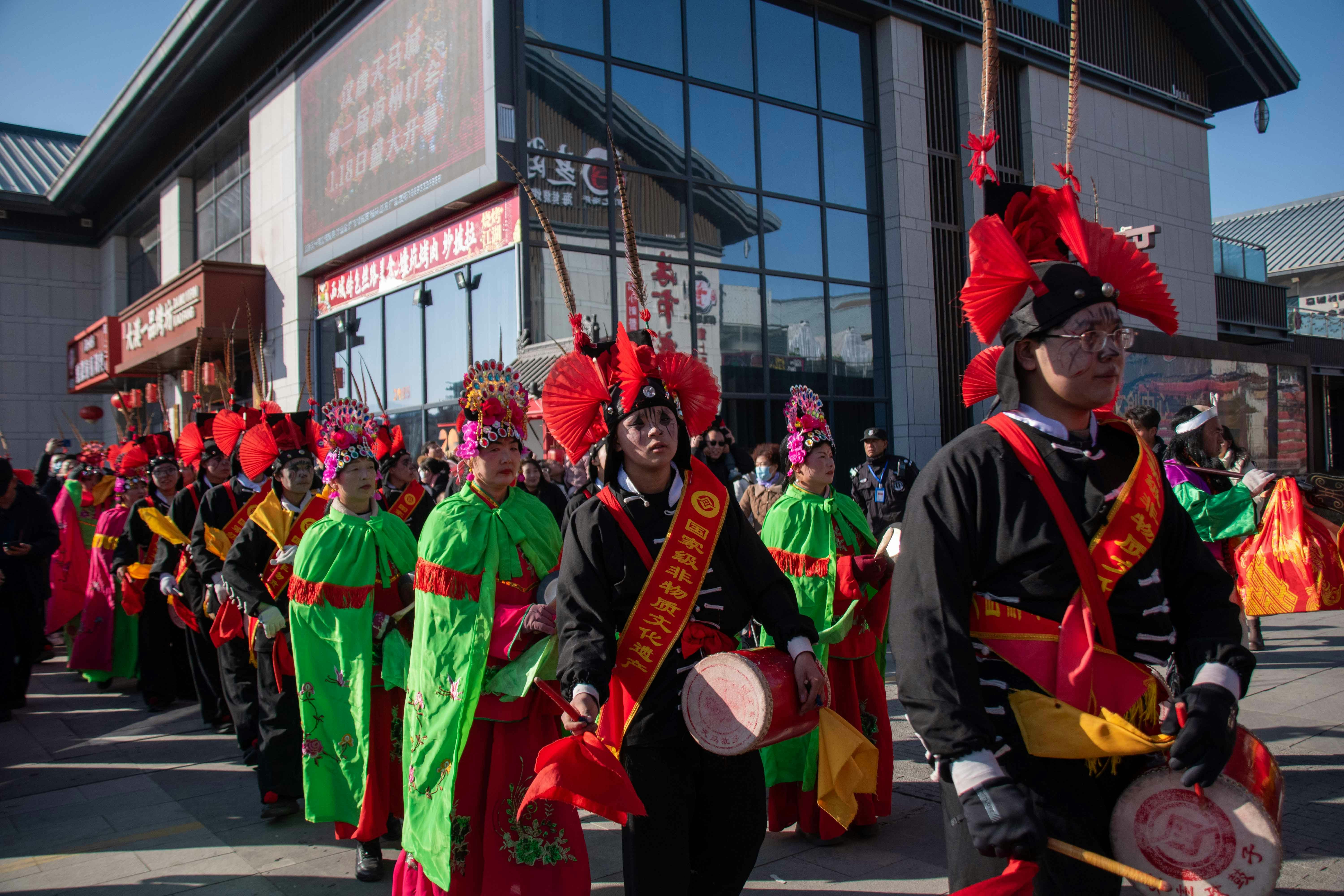 Des personnes en costumes traditionnels défilant dans un défilé
