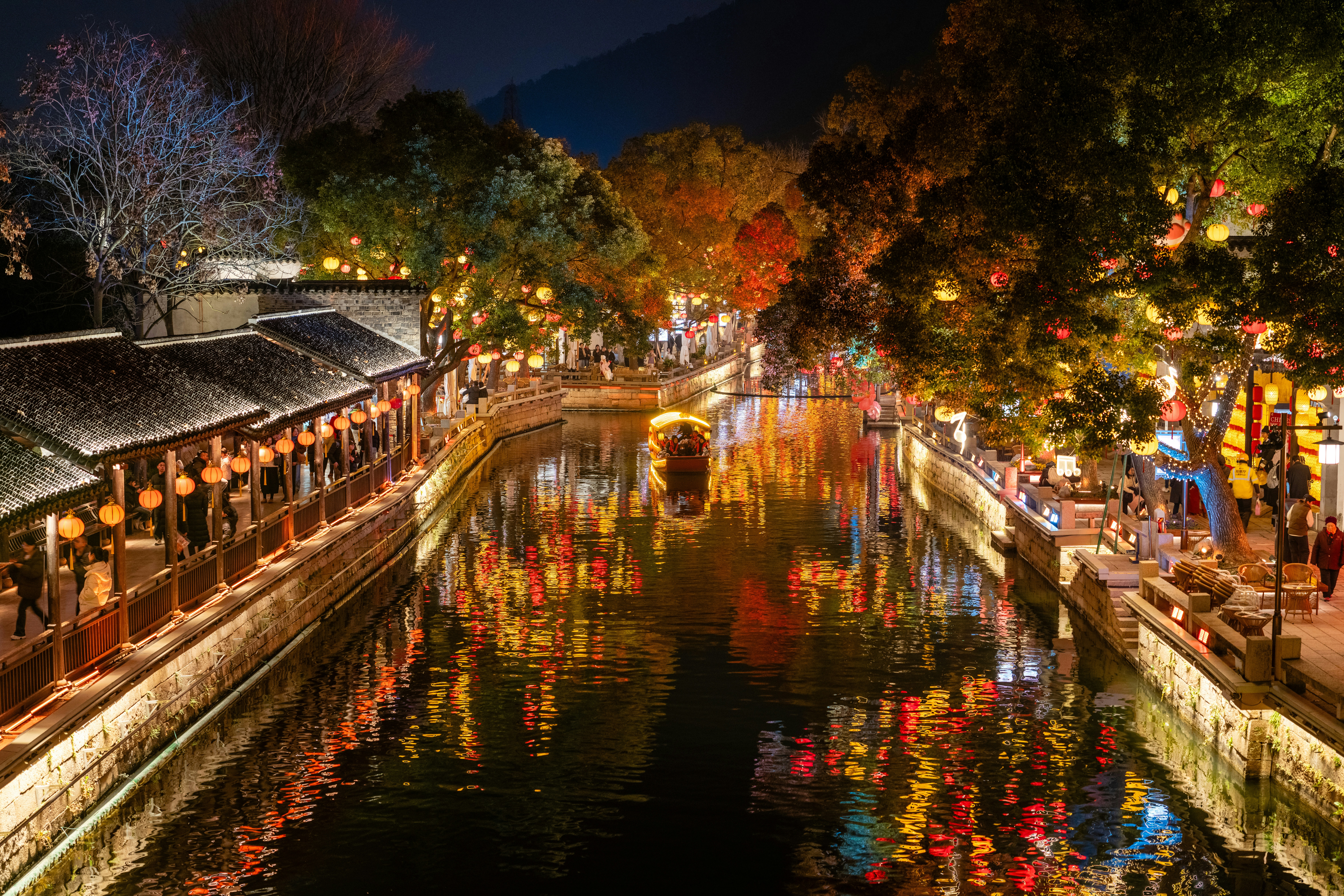 夜になると、照明に照らされた建物や木々が並ぶ運河。