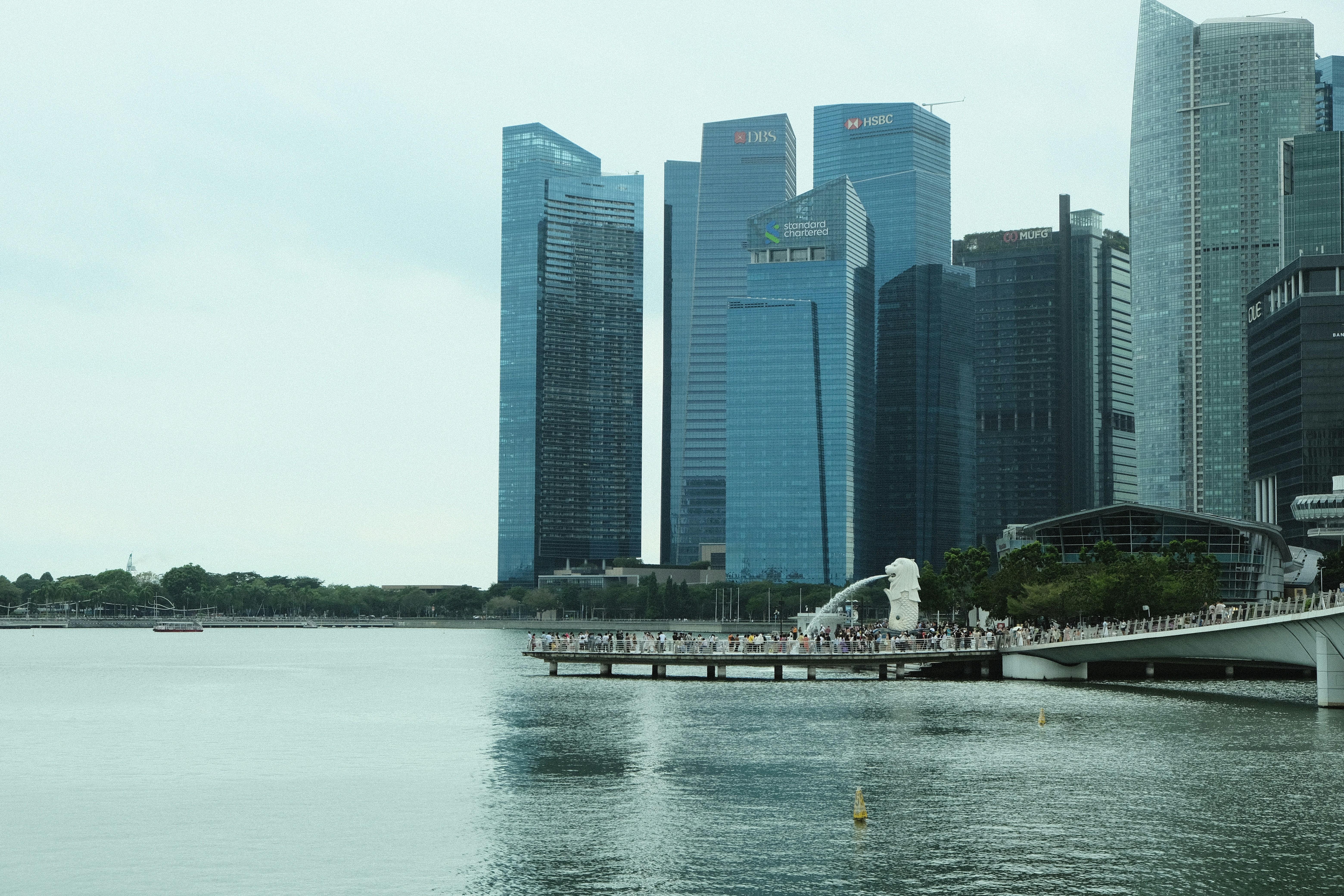 Modern skyscrapers rise above a waterfront promenade.