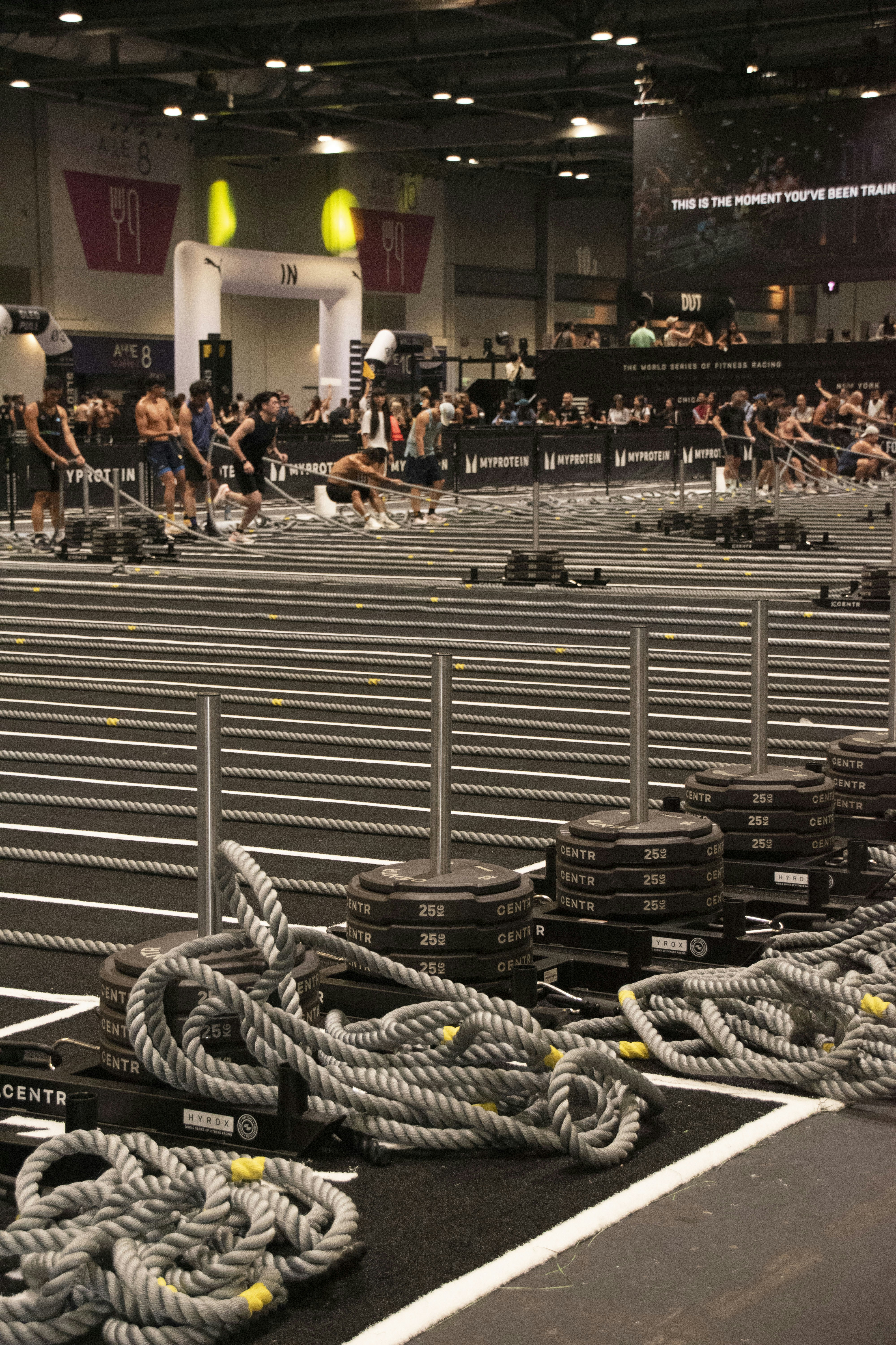 Athletes competing in a fitness competition with weights and equipment.