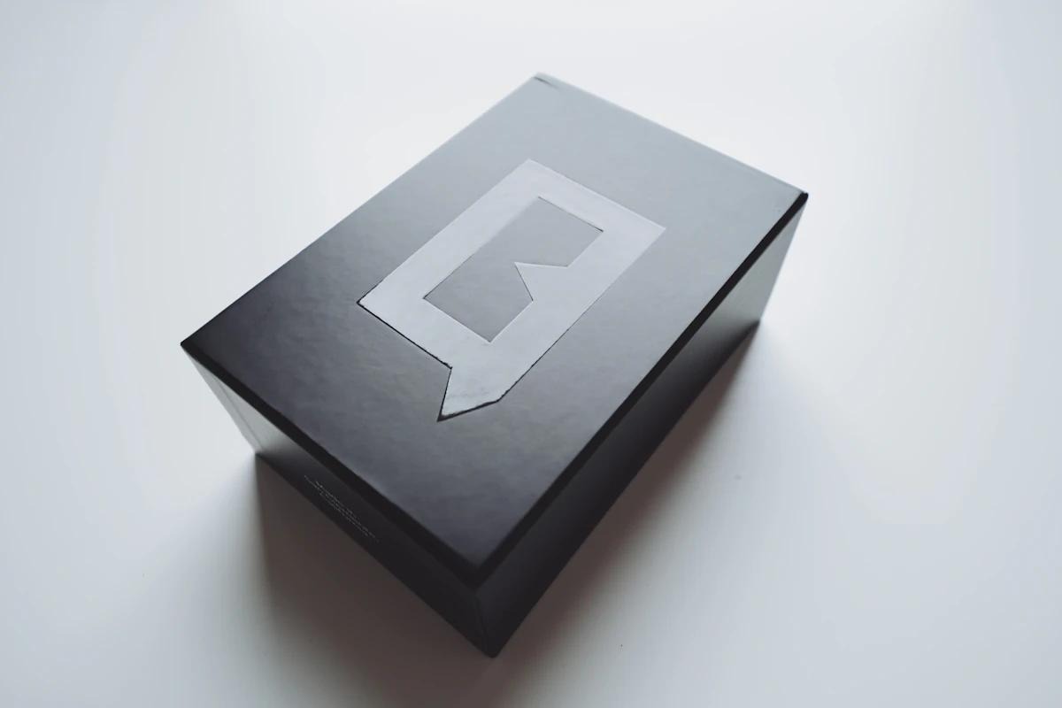 Matte black rigid presentation box with an embossed identity mark