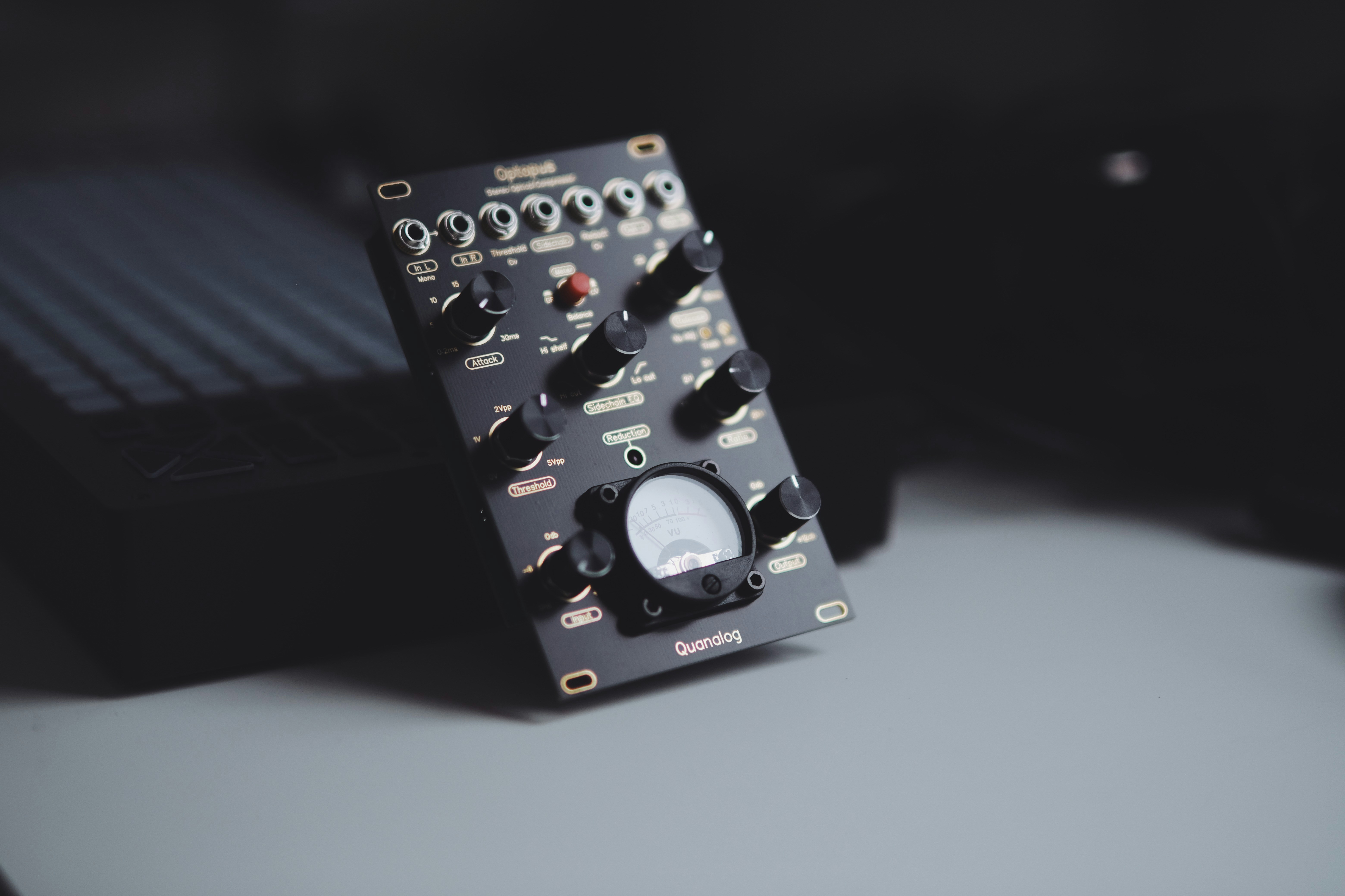 A black electronic device with knobs and a meter