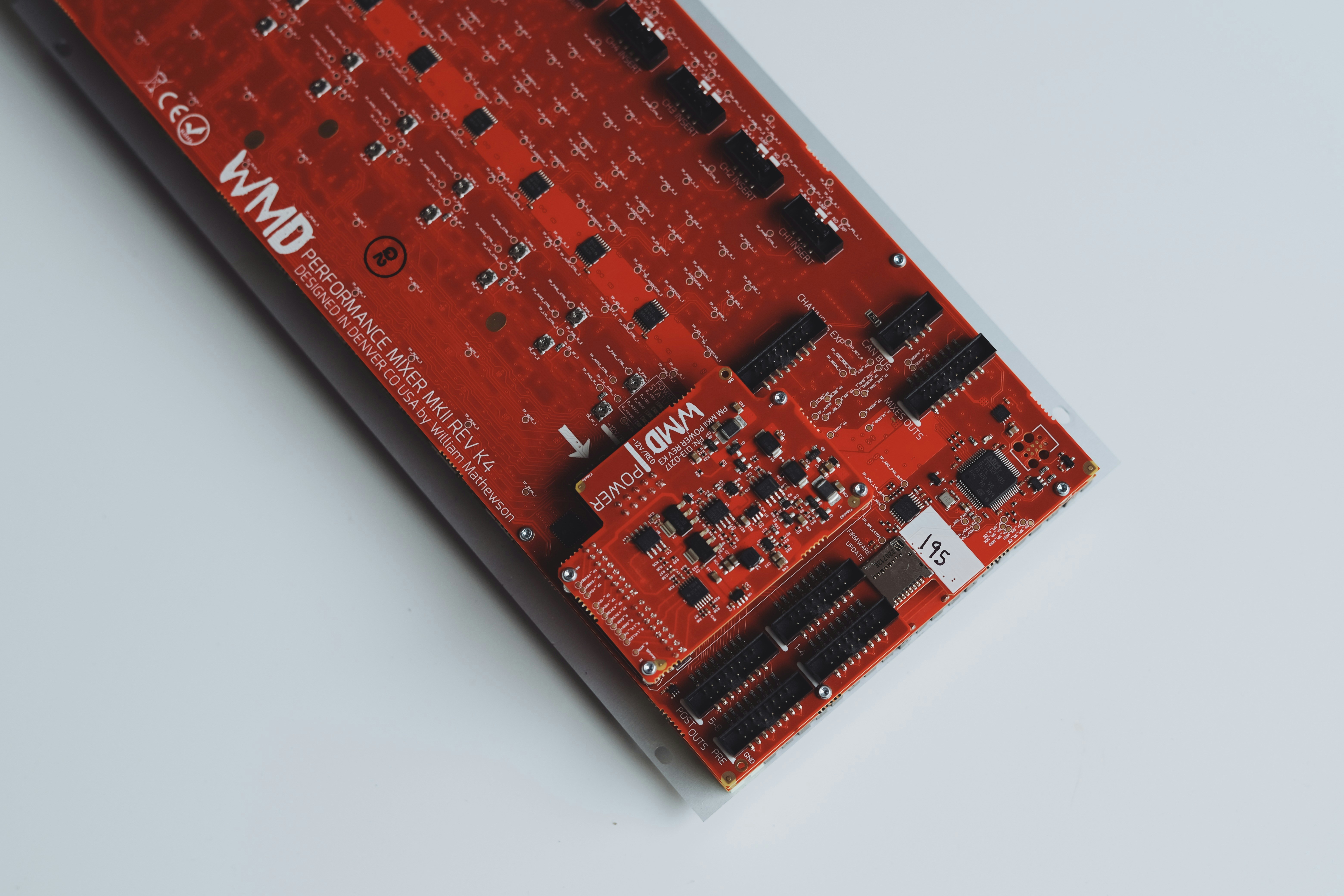 Red circuit board with black components and silver connectors