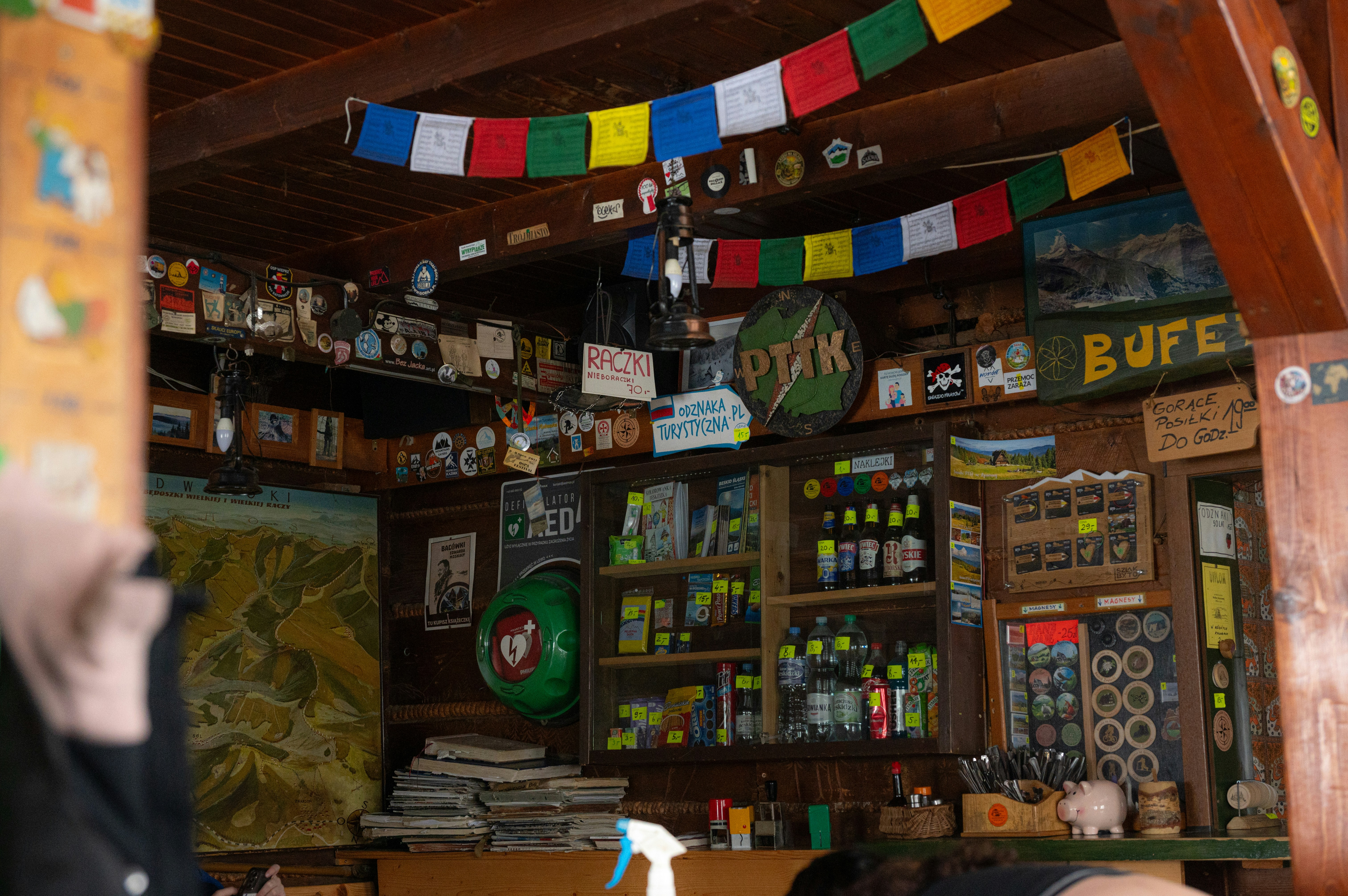 Cozy mountain hut interior with prayer flags and shelves.