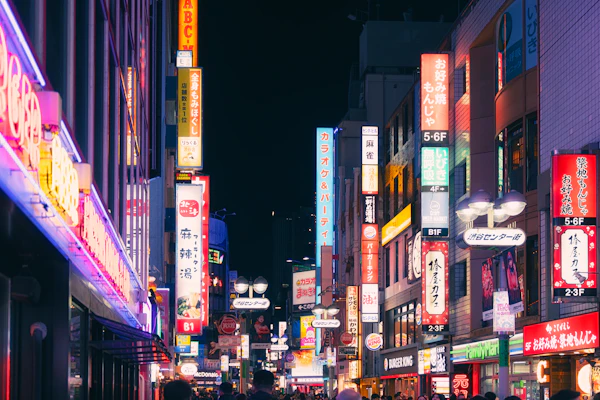 Neon signs light up a busy street in Shibuya, Tokyo, at night