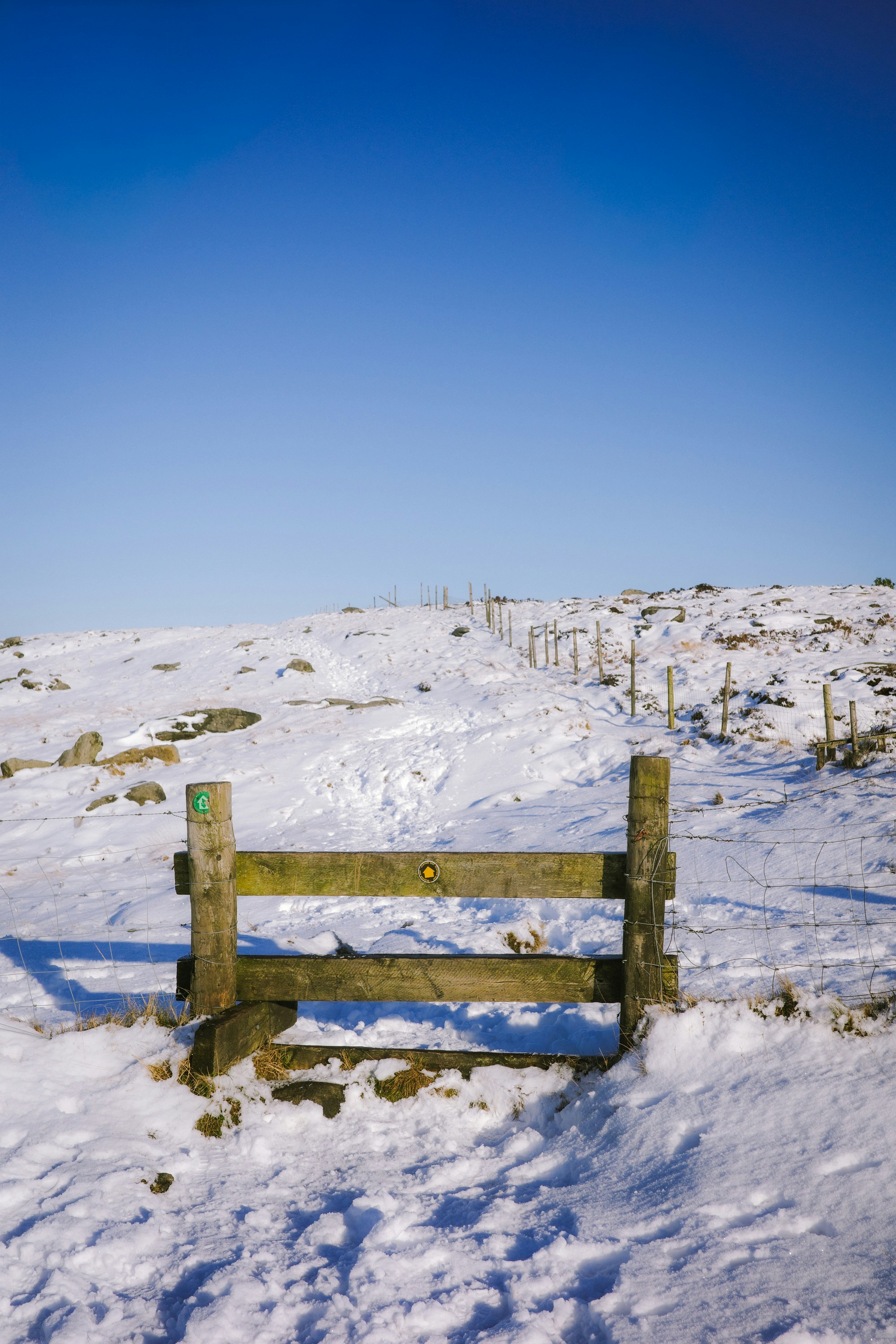 Wooden gate in a snowy landscape under a clear sky