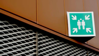 Green emergency assembly point sign on building