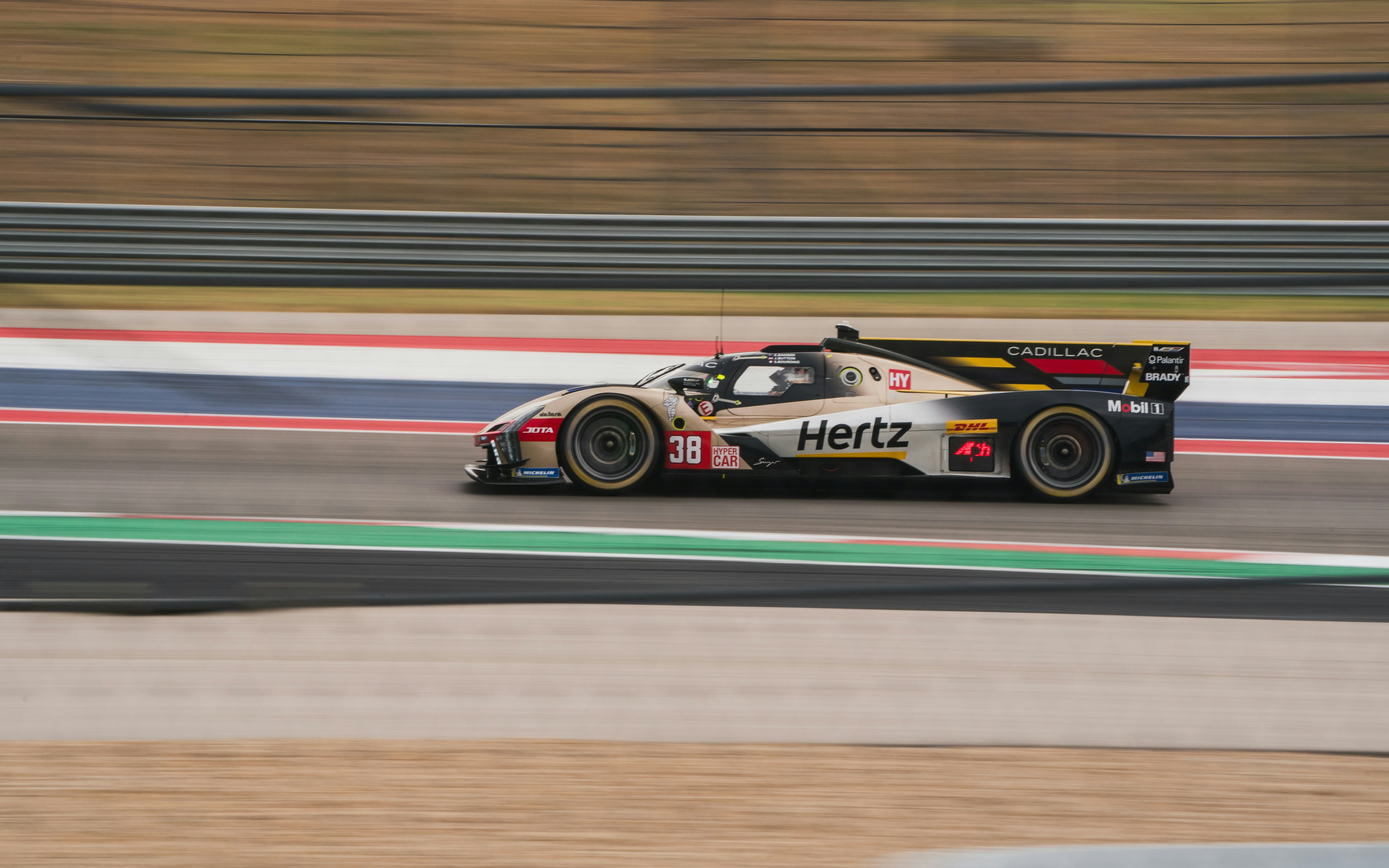 Race car speeding on a track with blurred background.