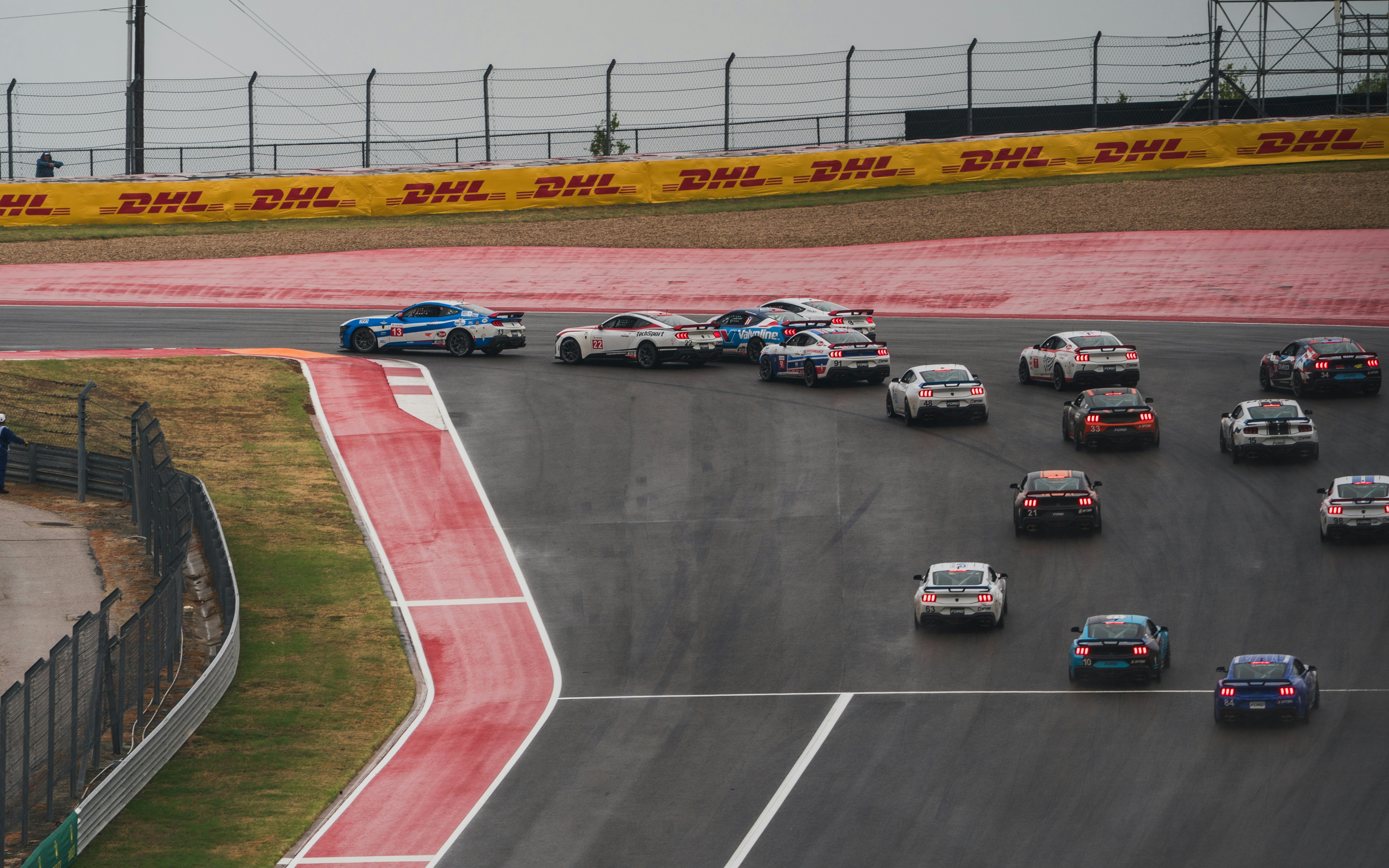 Race cars competing on a wet track during a race.