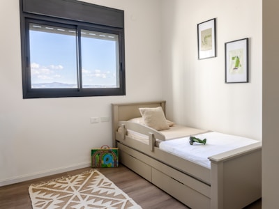 A child's bedroom with a twin bed and toys.