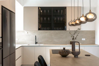 Modern kitchen with sleek cabinets and pendant lights.