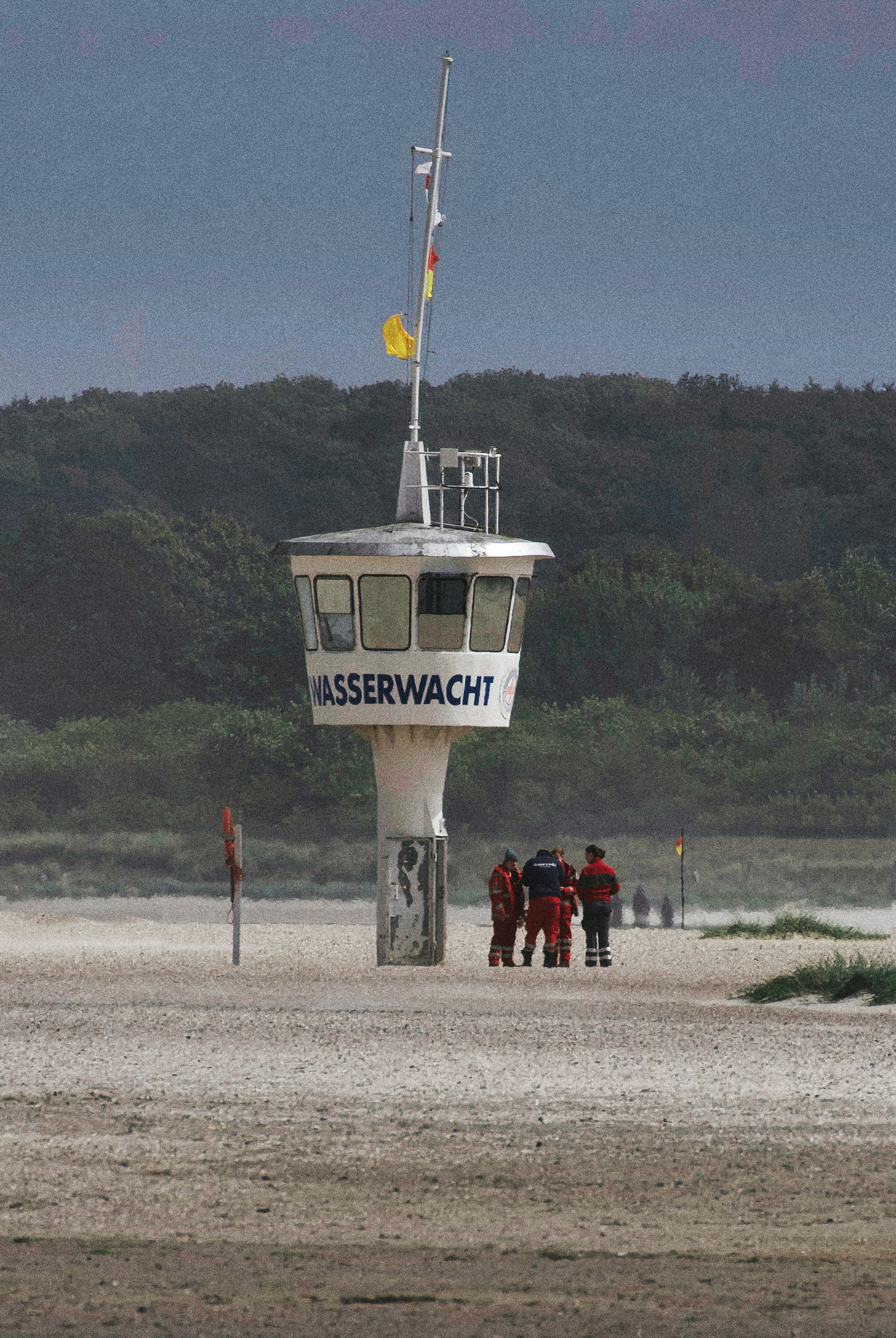 Lifeguard tower on a sandy beach with people.