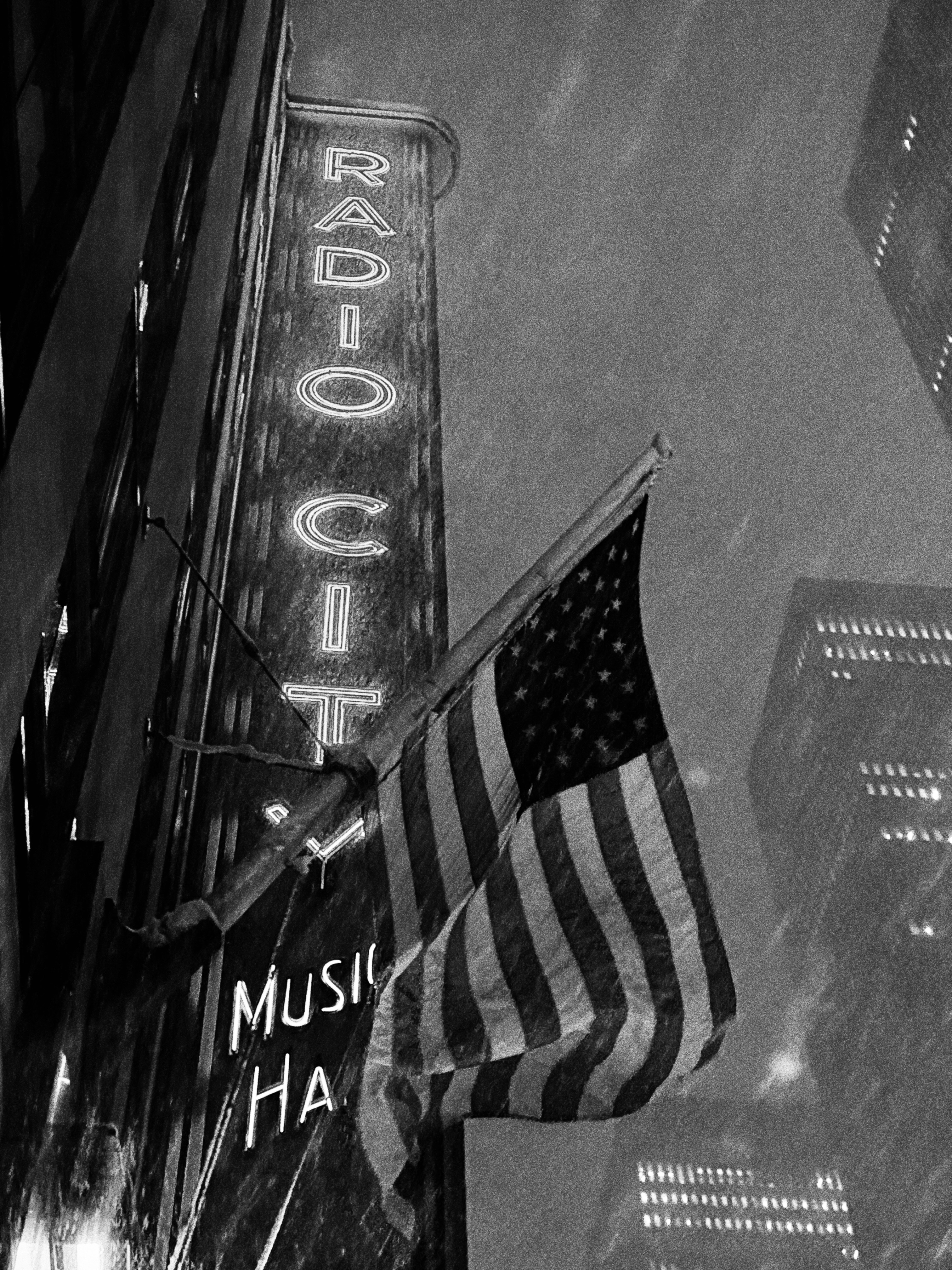 Radio city music hall sign with american flag at night.
