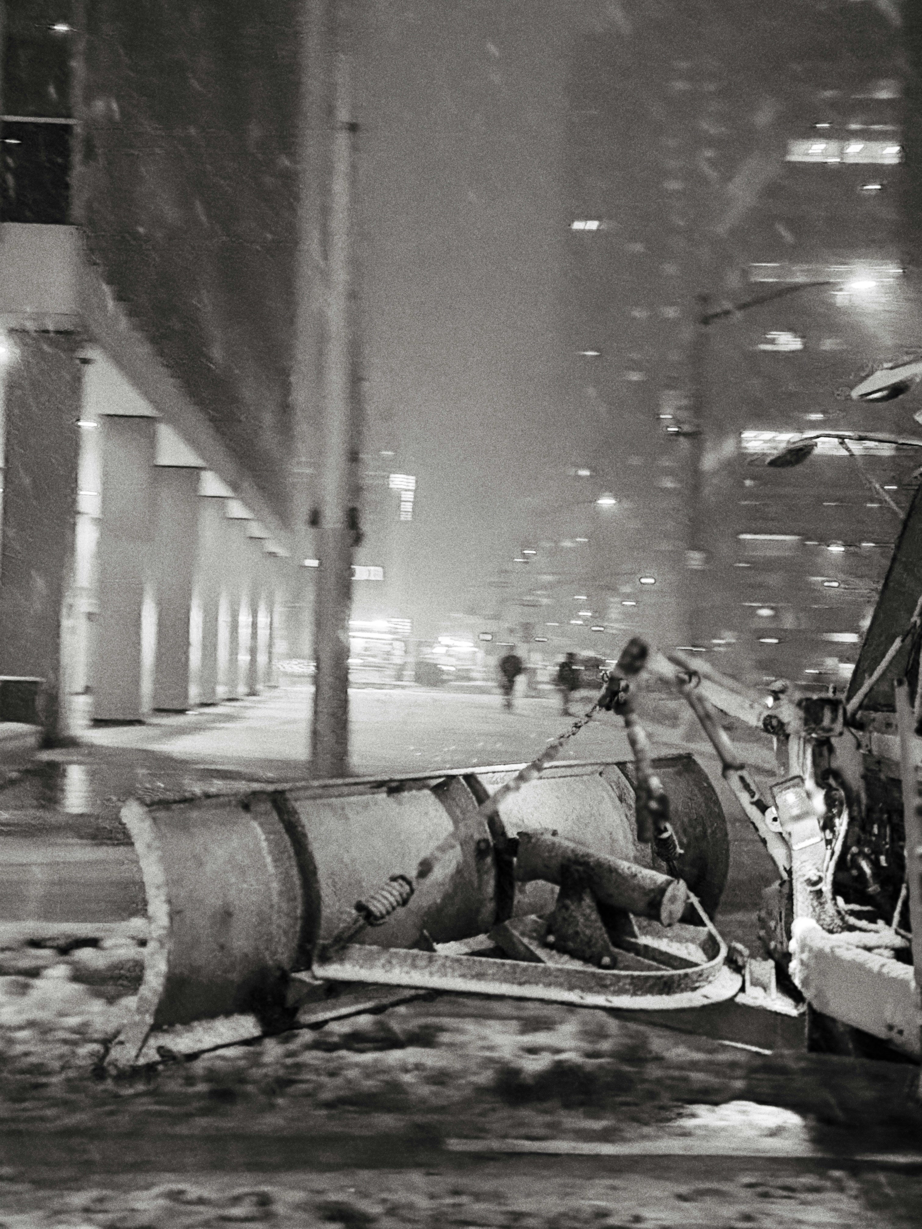 Snow plow clearing a city street at night