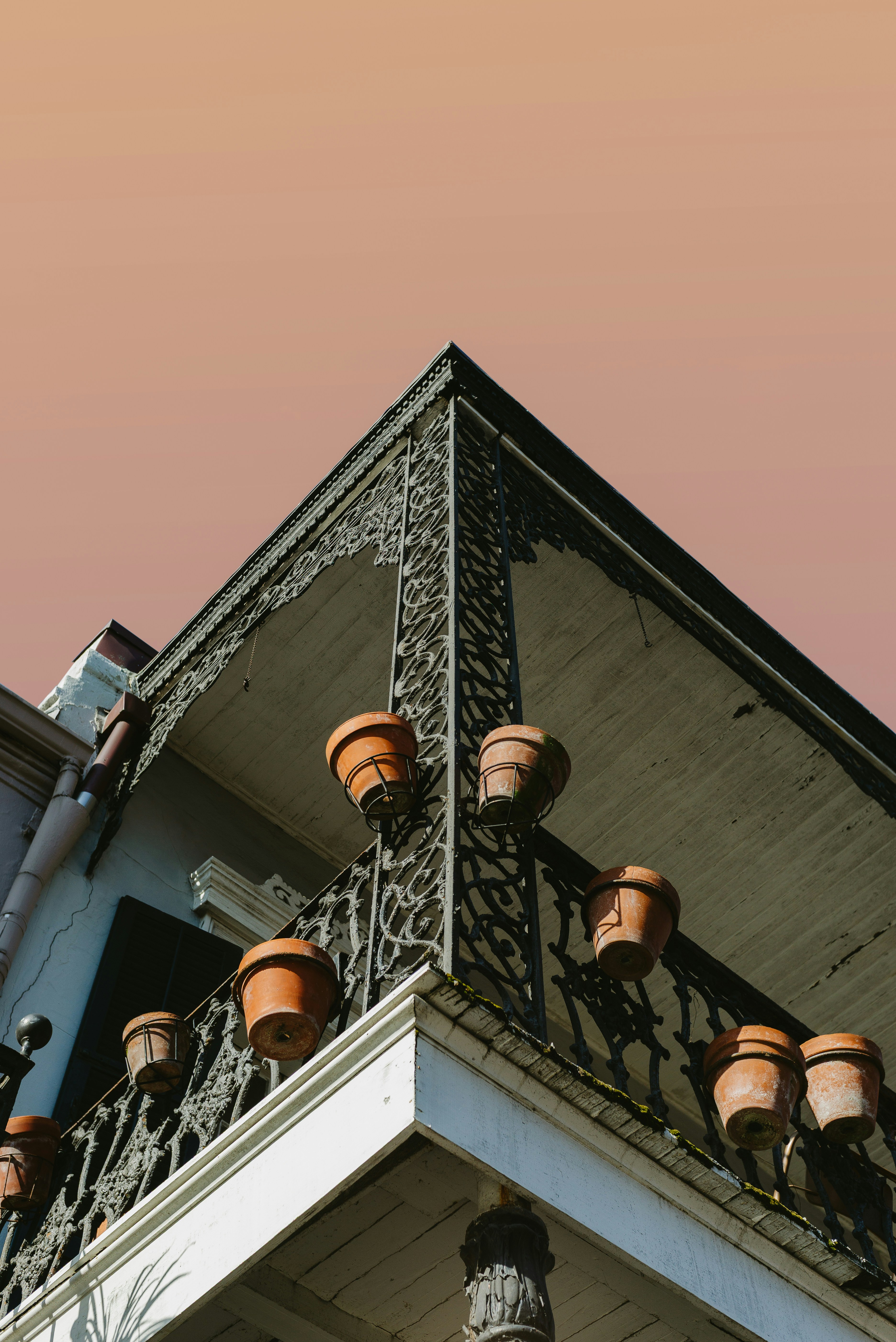Vasi di terracotta adornano una ringhiera in ferro battuto del balcone.