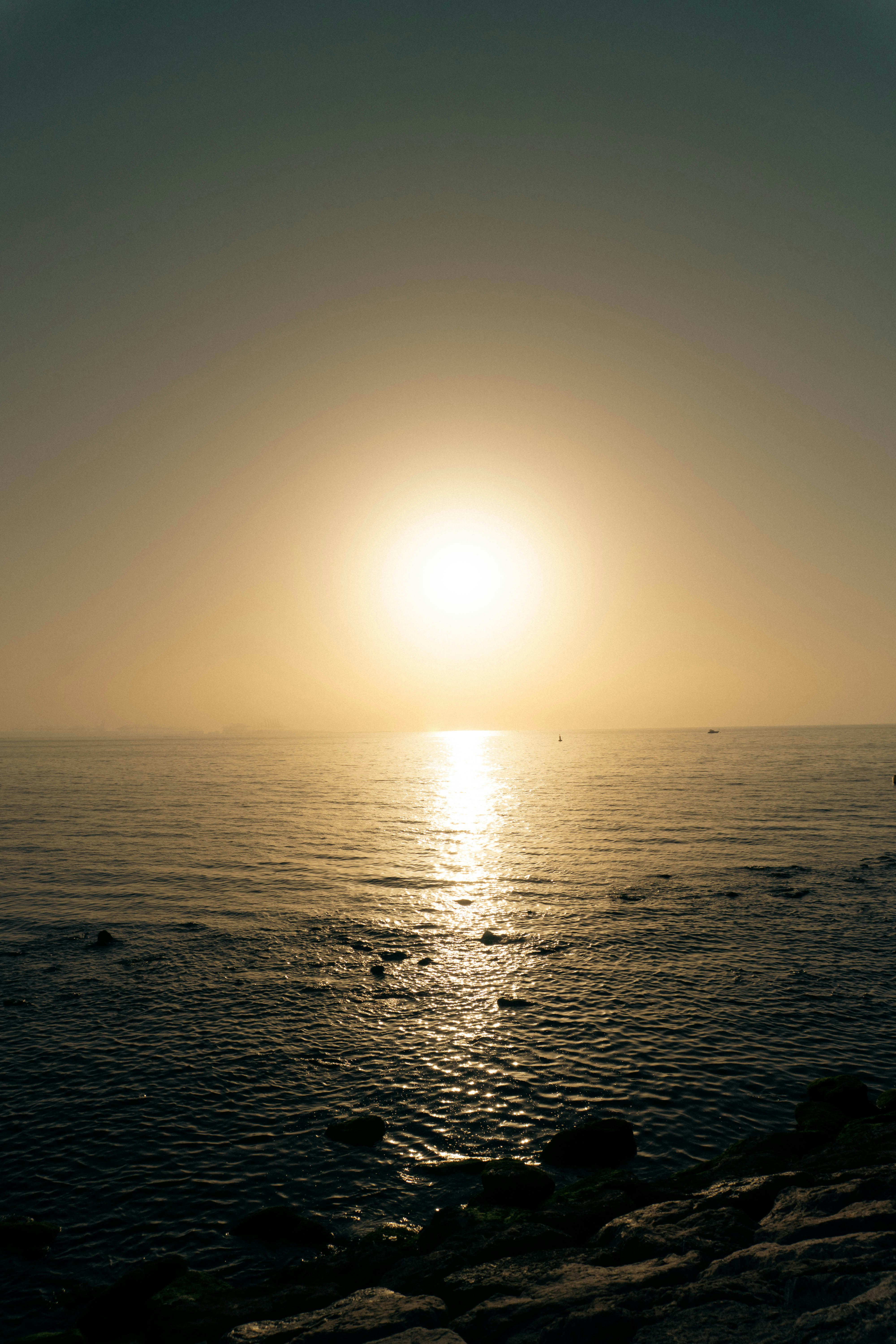 Golden sun setting over a calm ocean horizon.