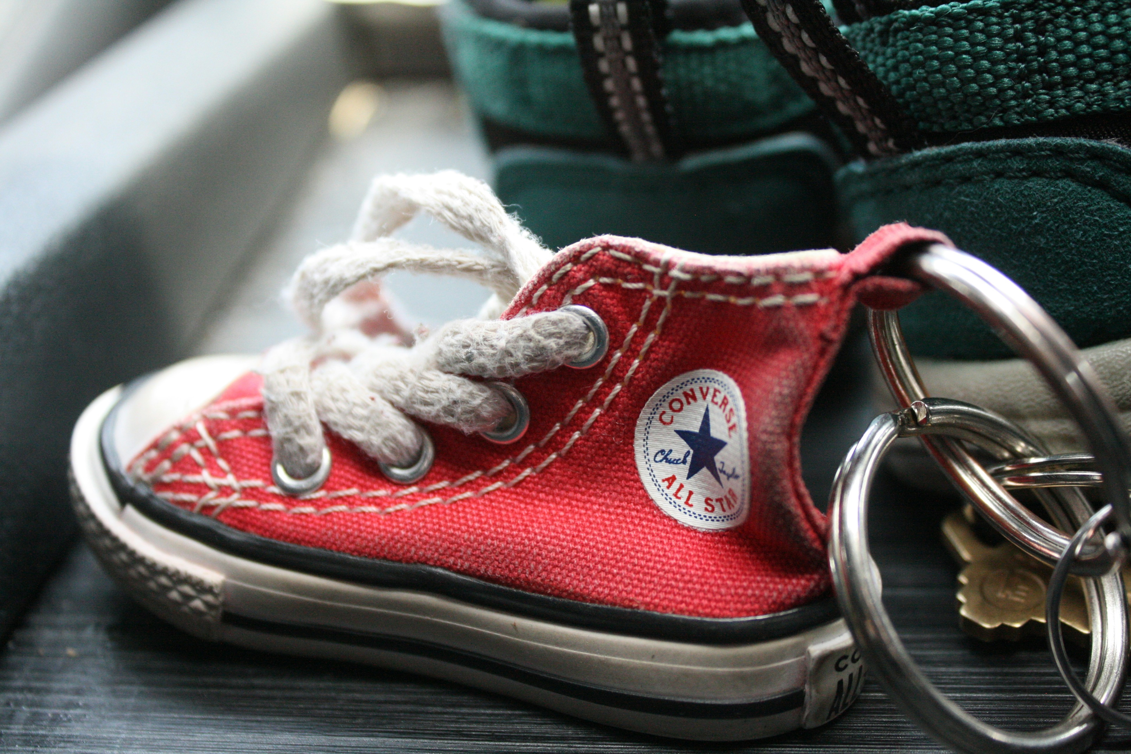 A red converse sneaker keychain with keys.