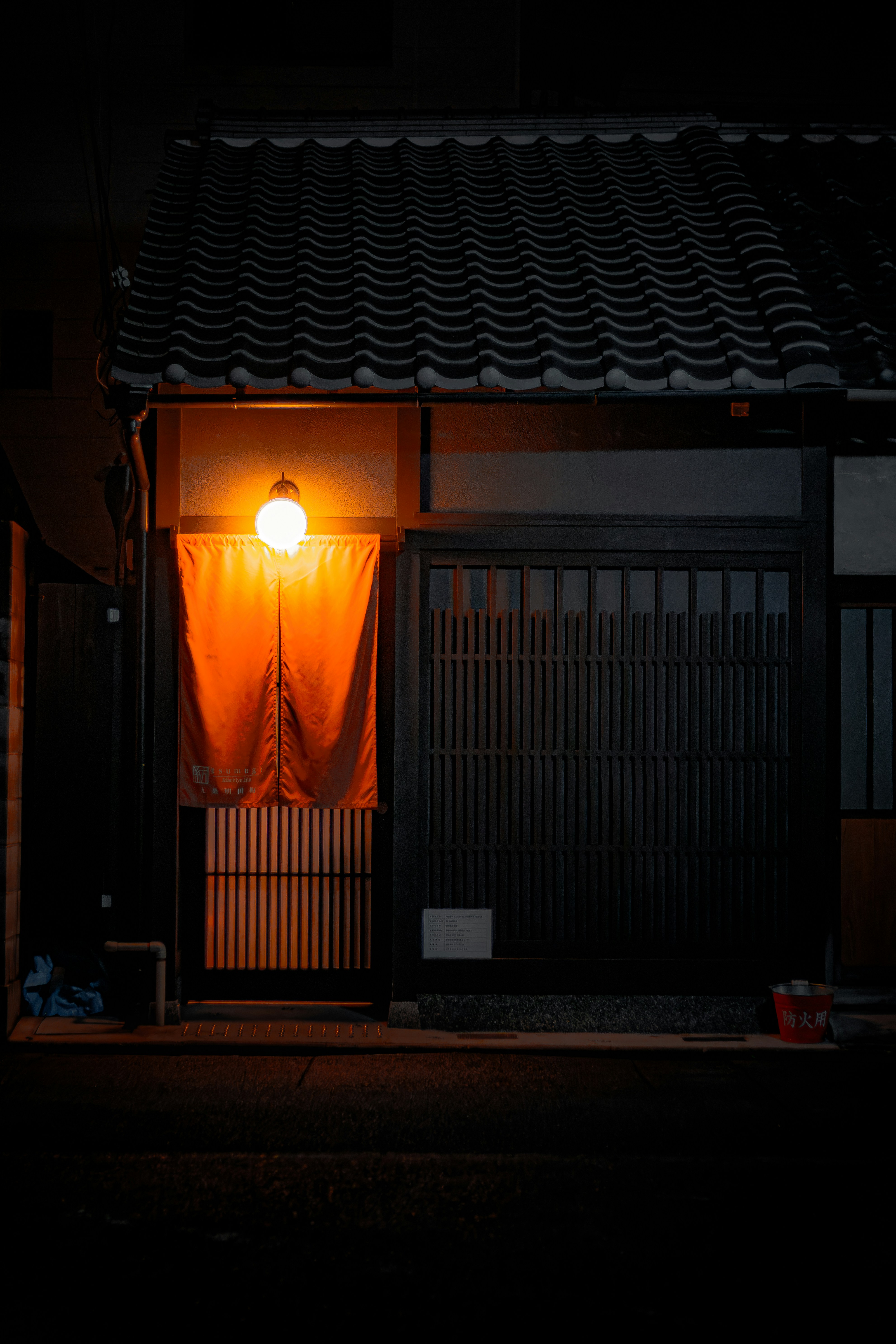 Traditional japanese building entrance at night with warm light.