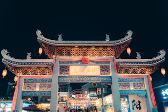 Ornate traditional chinese gate illuminated at night
