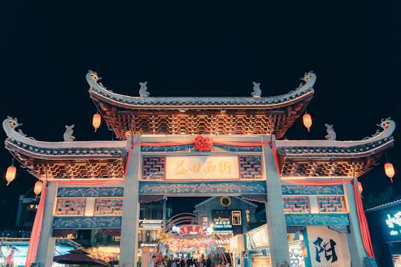 Ornate traditional chinese gate illuminated at night
