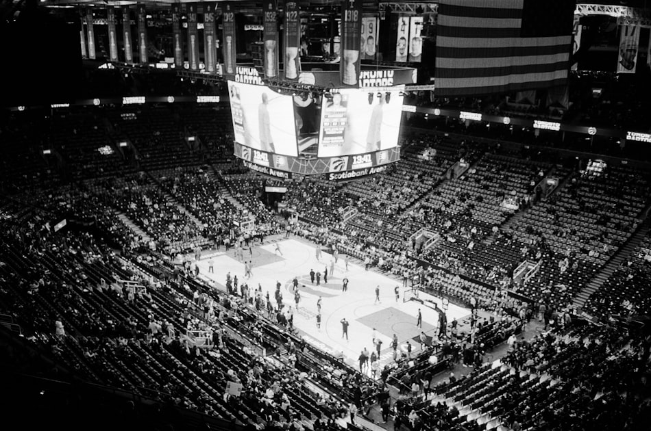 Packed basketball arena during a high-energy game under bright stadium lights