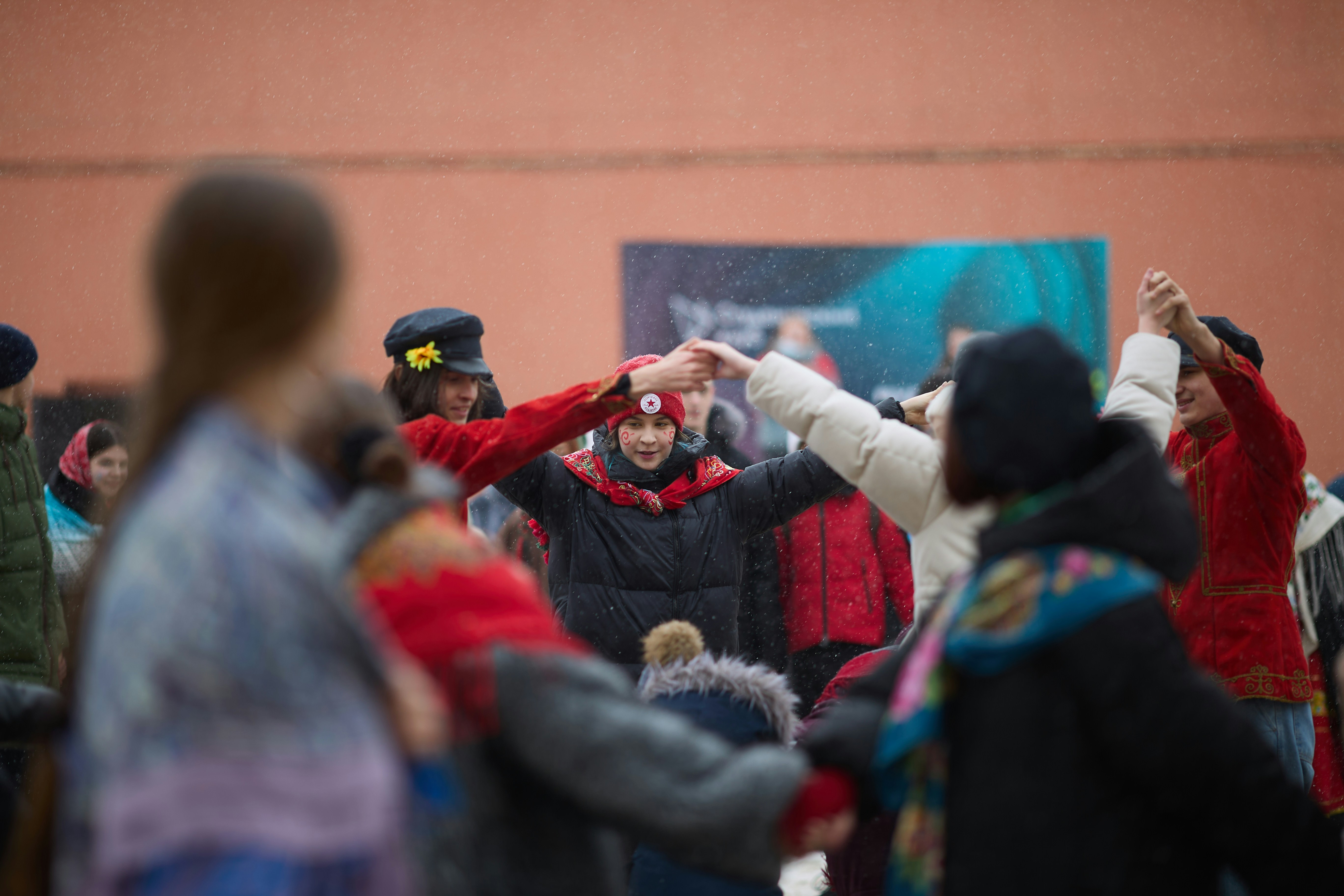 人々が手をつないで円を描いて踊っている