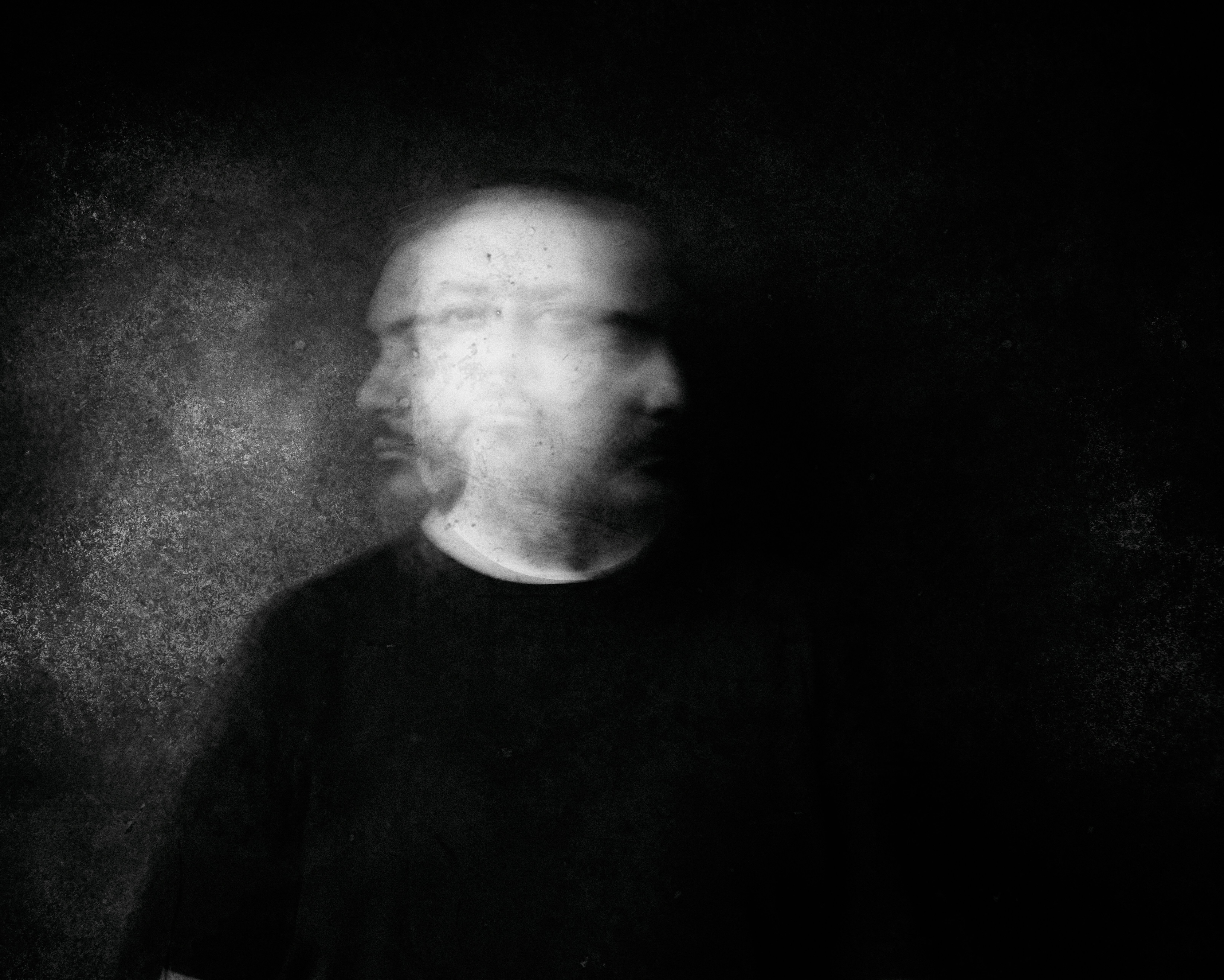 Blurred man's face in dark, moody lighting