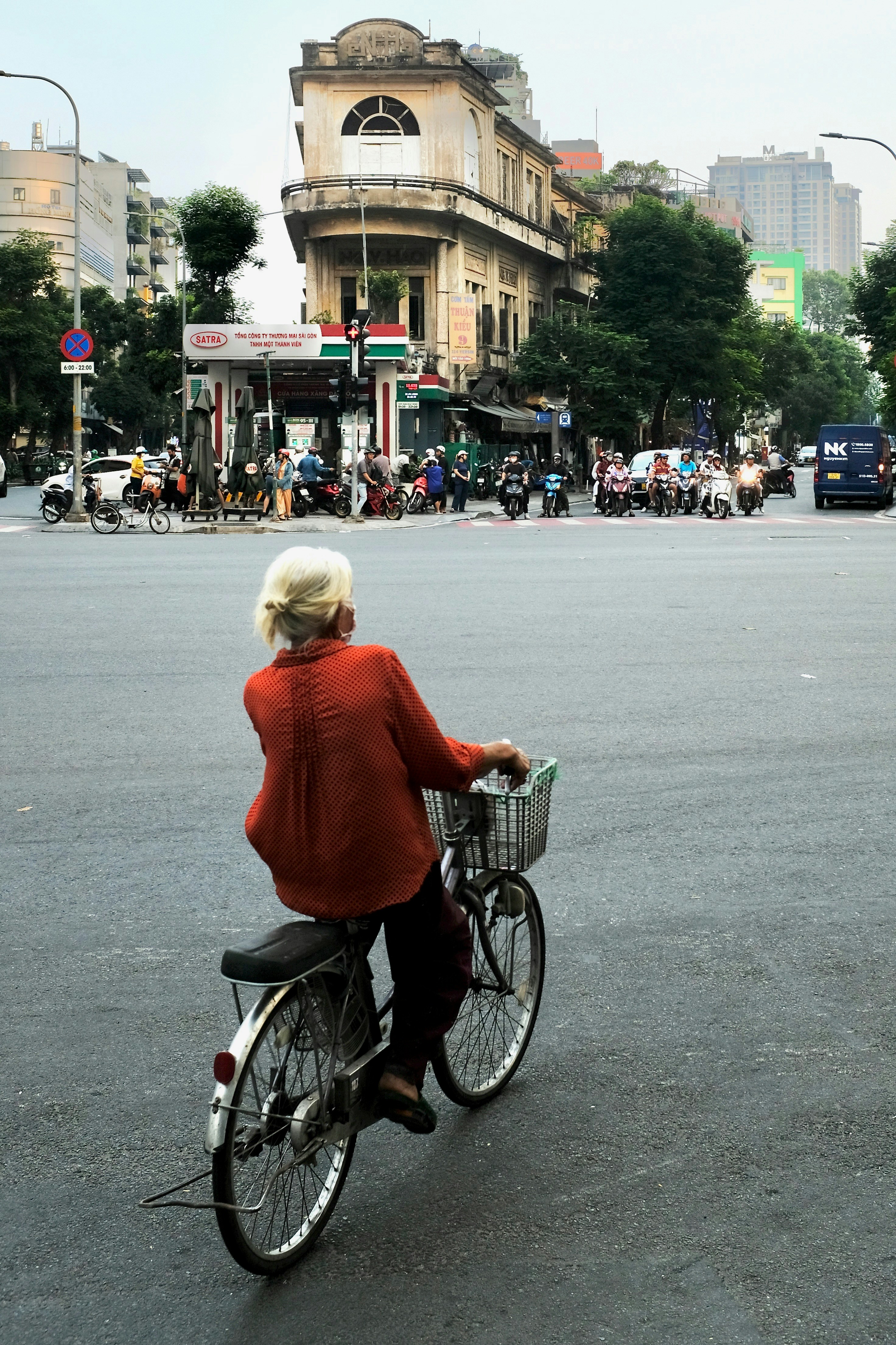 Elderly woman on bicycle at city intersection