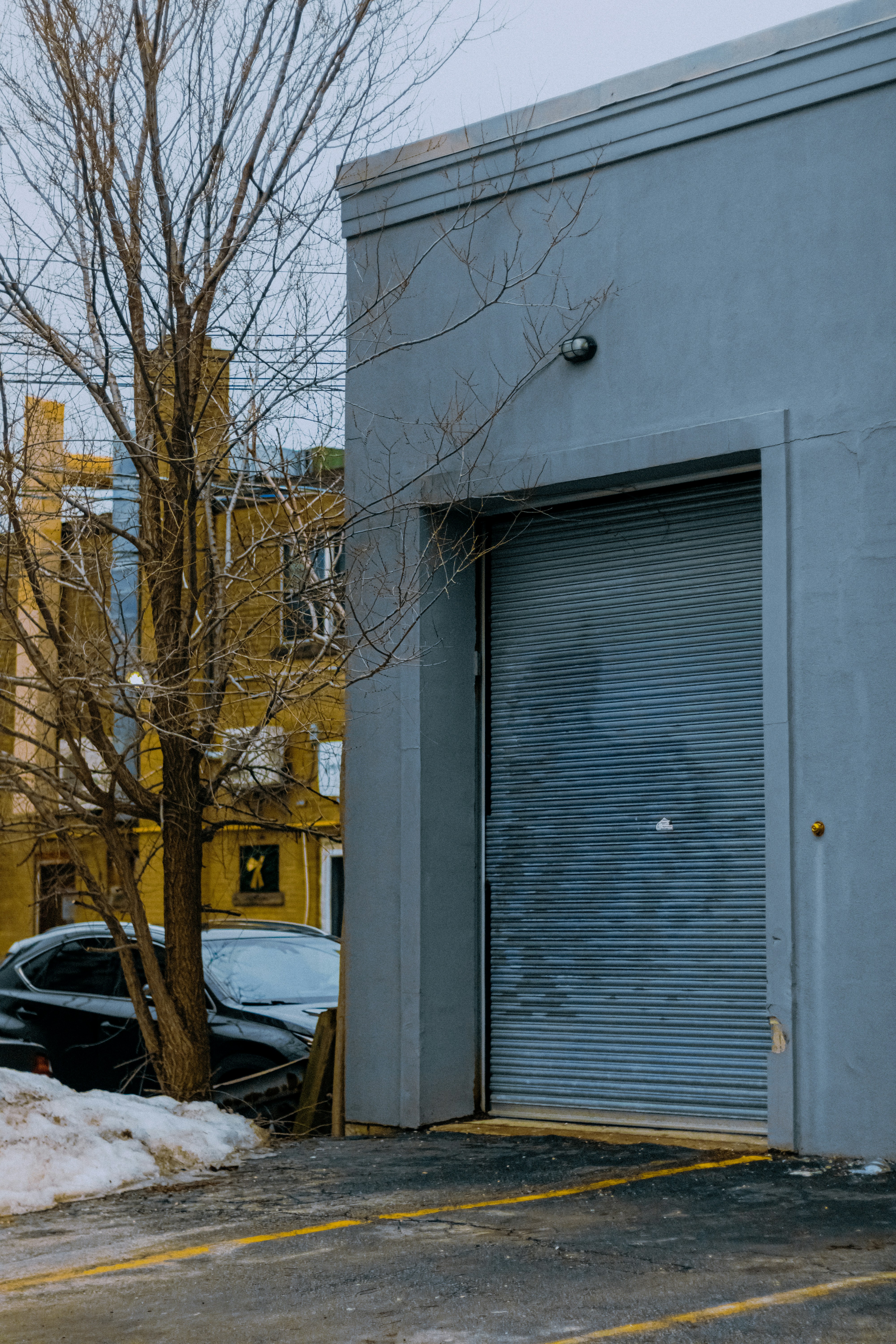 Gray industrial building with large roll-up door.