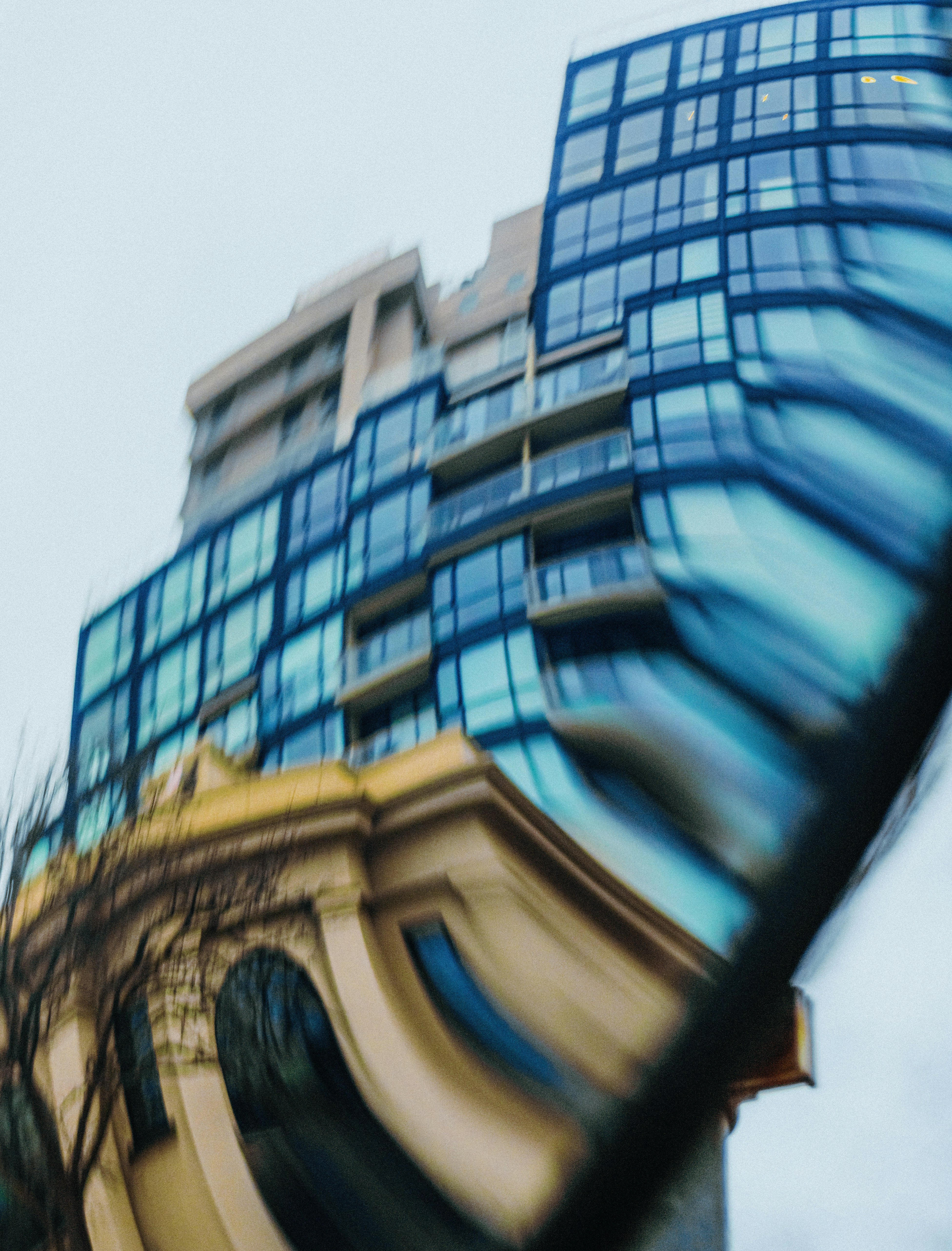 Modern blue glass building with distorted reflection