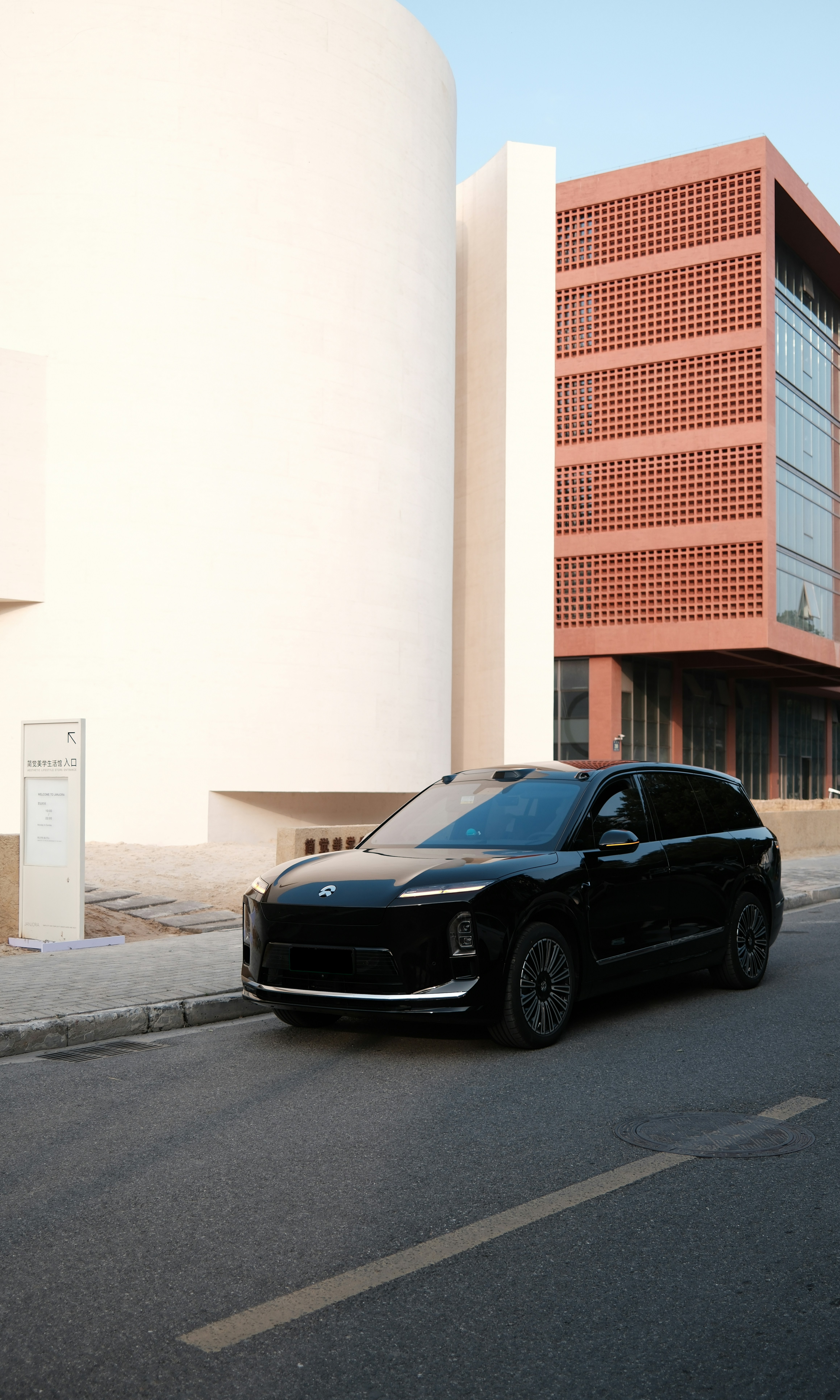 SUV negro de lujo aparcado en la calle cerca de edificios modernos.