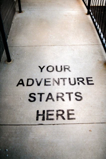 Your adventure starts here painted on sidewalk