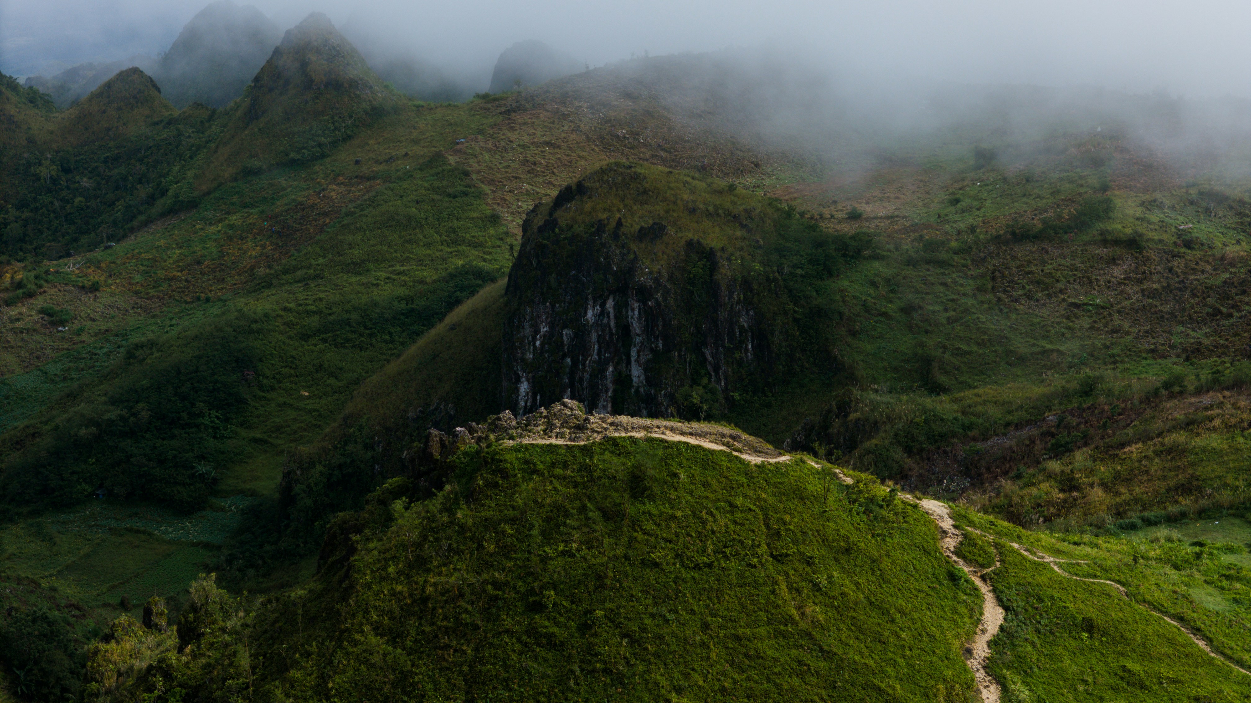 Misty green mountains with a winding path