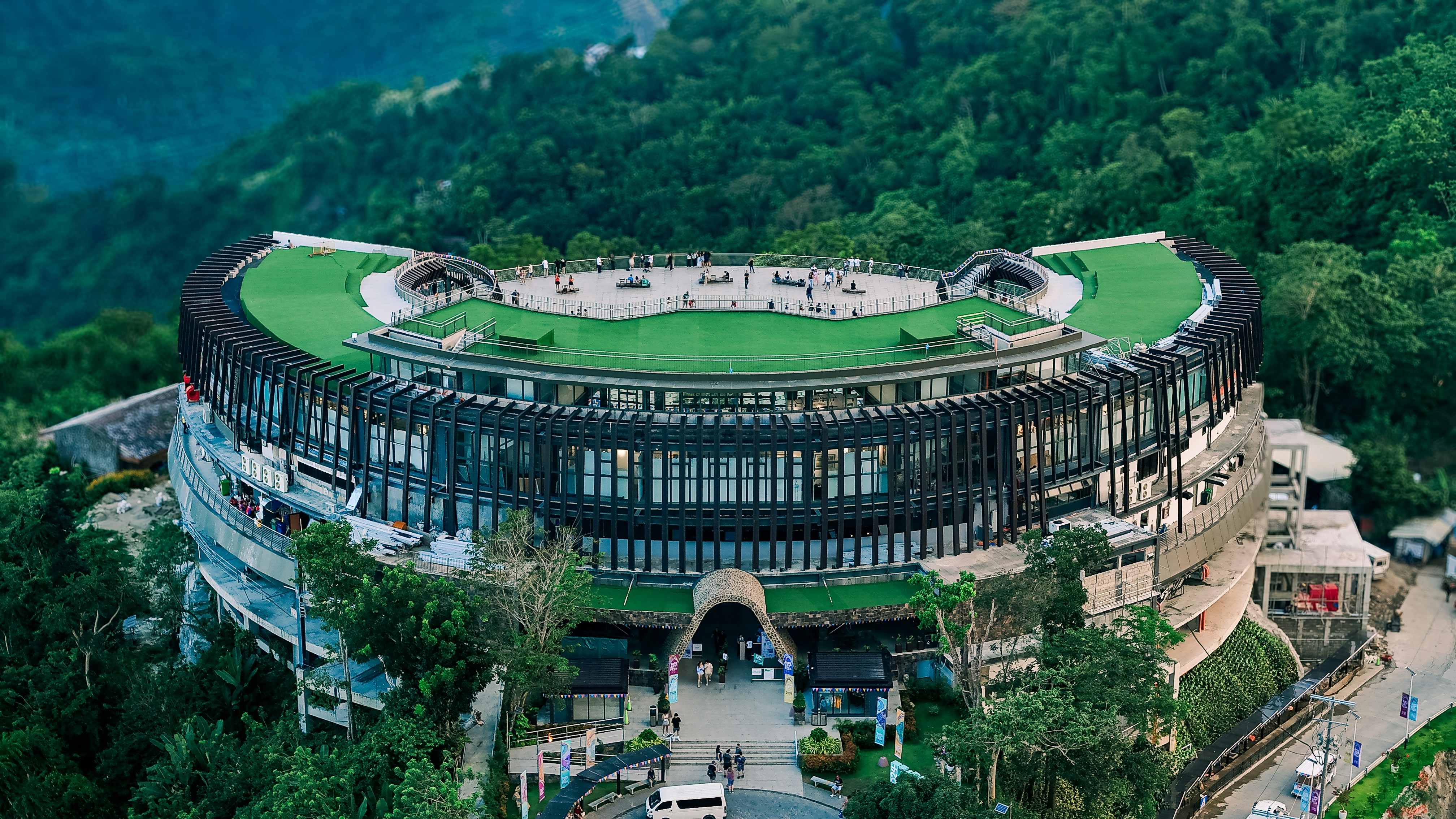 Modern circular building nestled in a lush green forest.