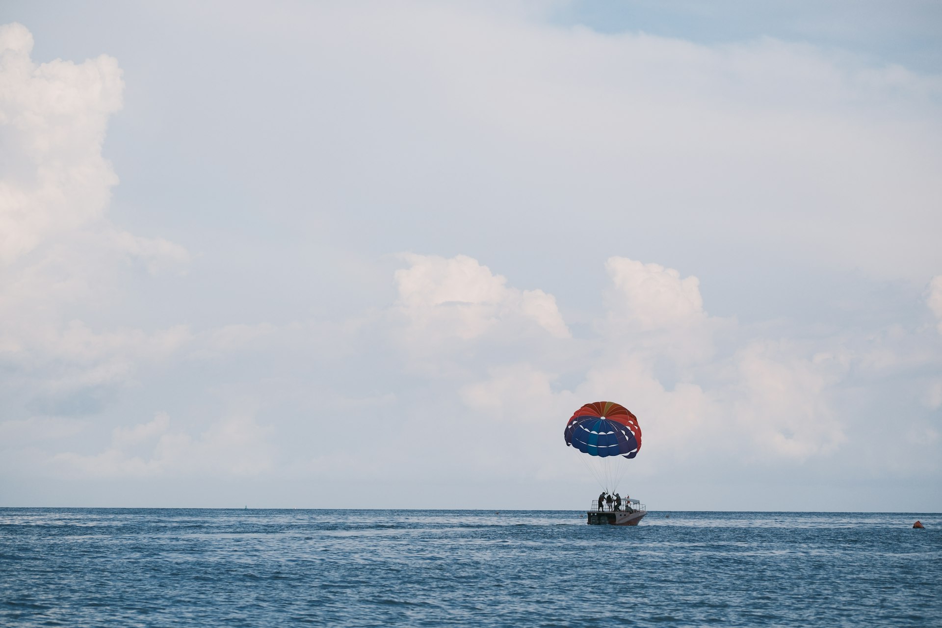Parasailing over the ocean with a boat below.