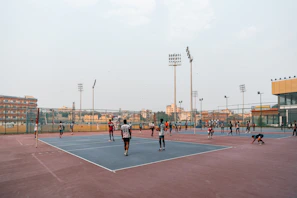 People playing volleyball on an outdoor court.
