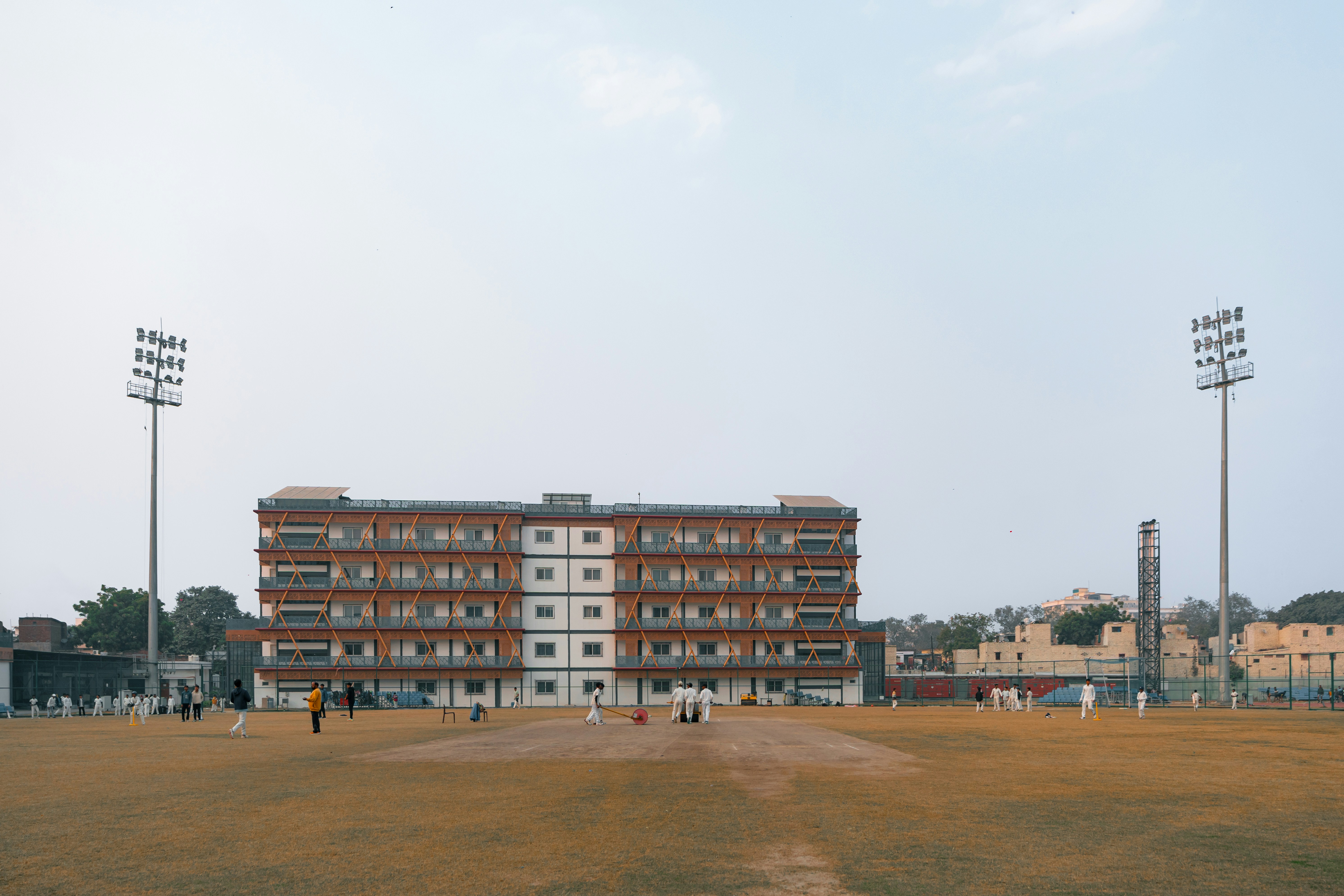 Cricket field with stadium lights and building