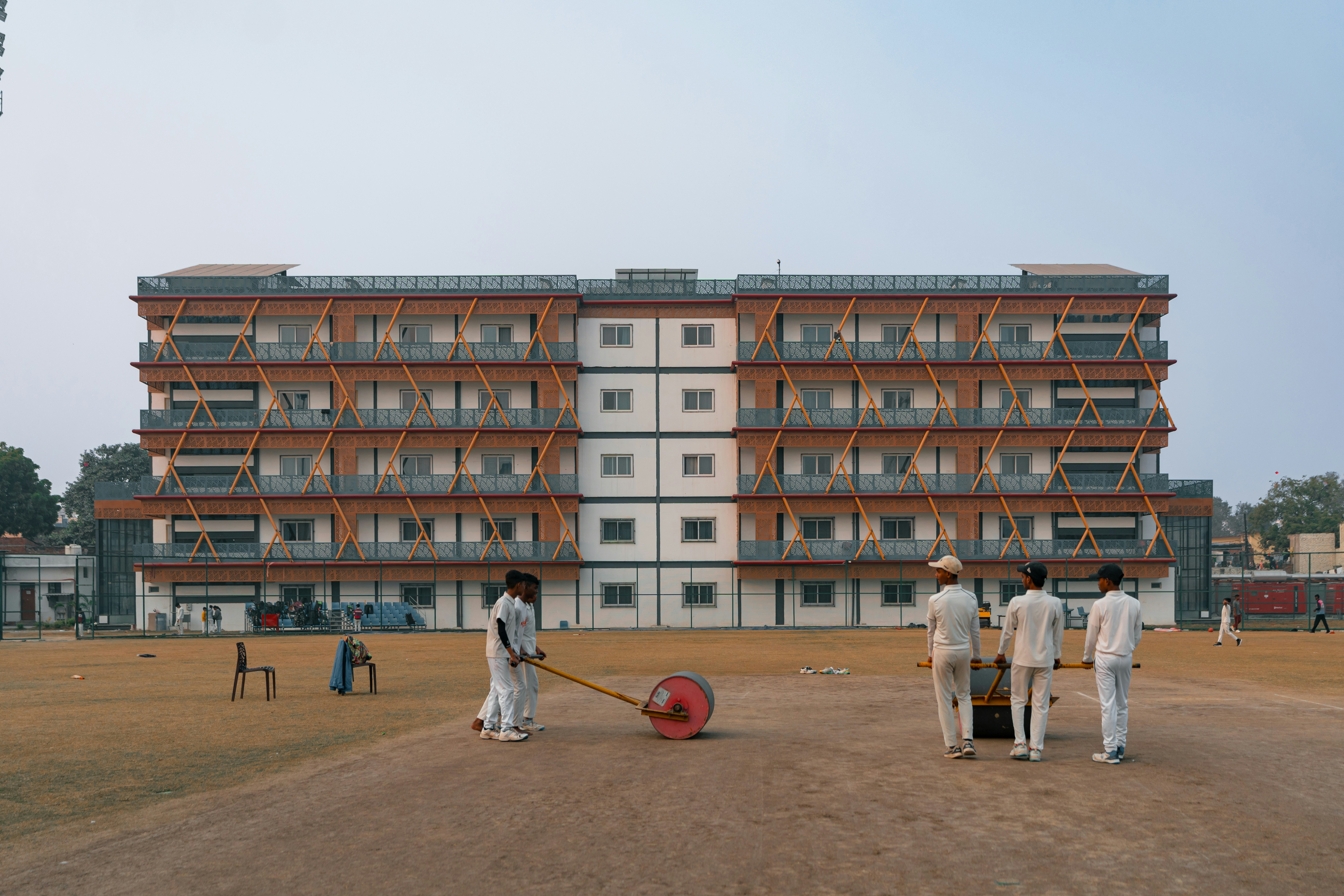 Jugadores de cricket preparando el campo frente al edificio