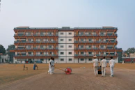 Cricket players preparing field in front of building