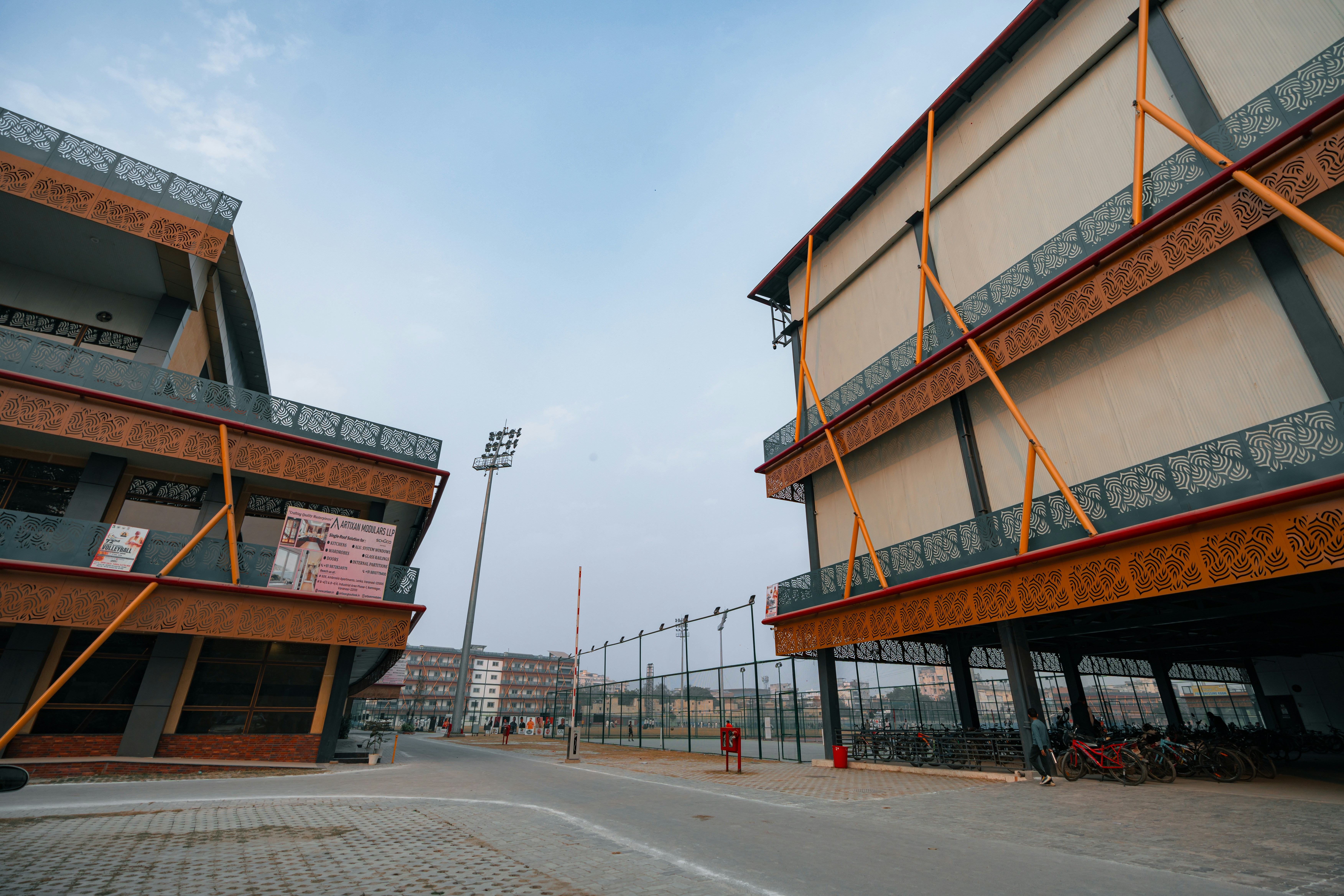 Modern buildings with orange accents and a stadium light