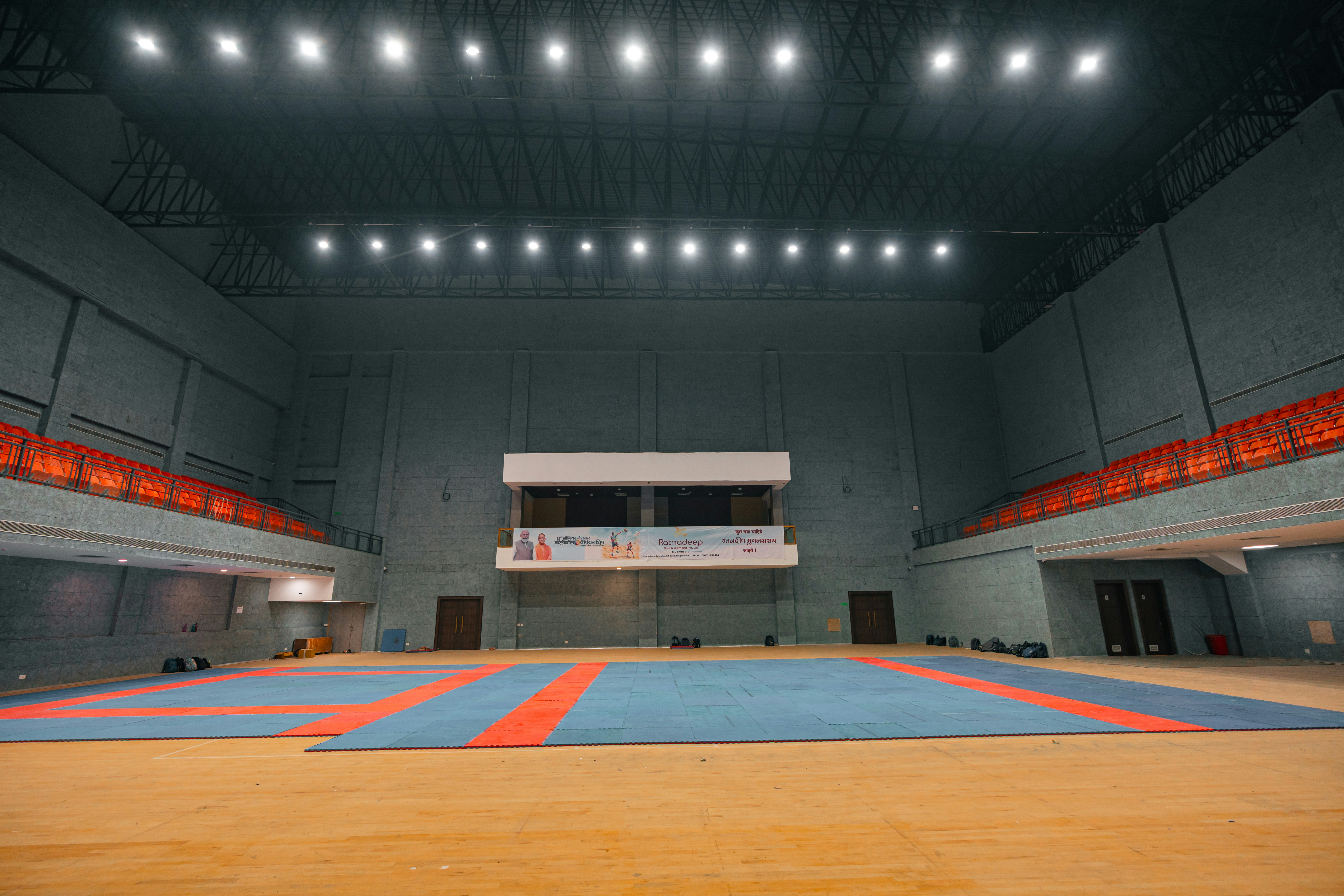 Público en un recinto cerrado con luces de concierto y celulares en alto