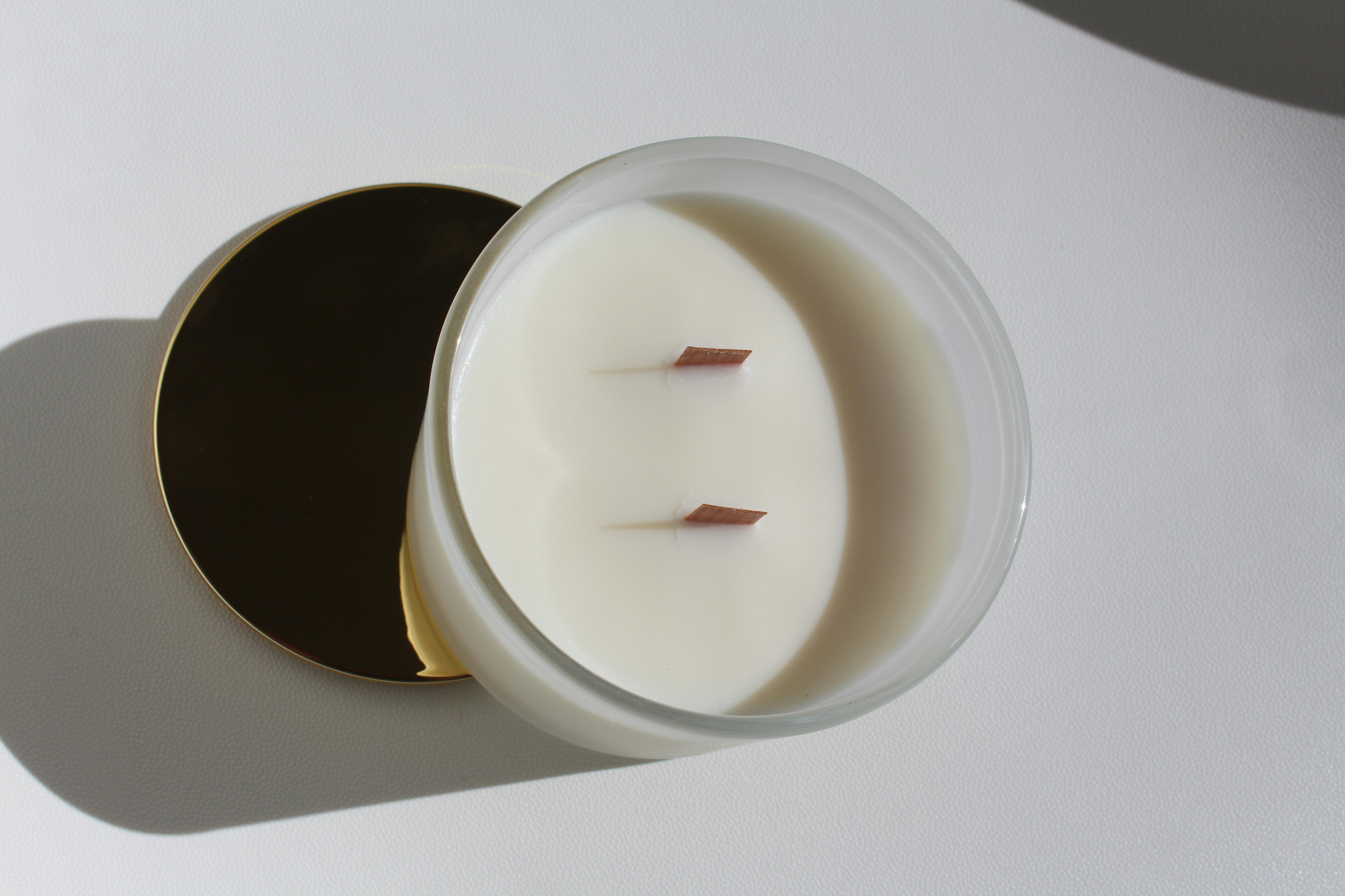 Une bougie blanche avec deux mèches en bois.