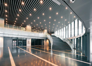 Modern interior with a grand staircase and bright lighting.