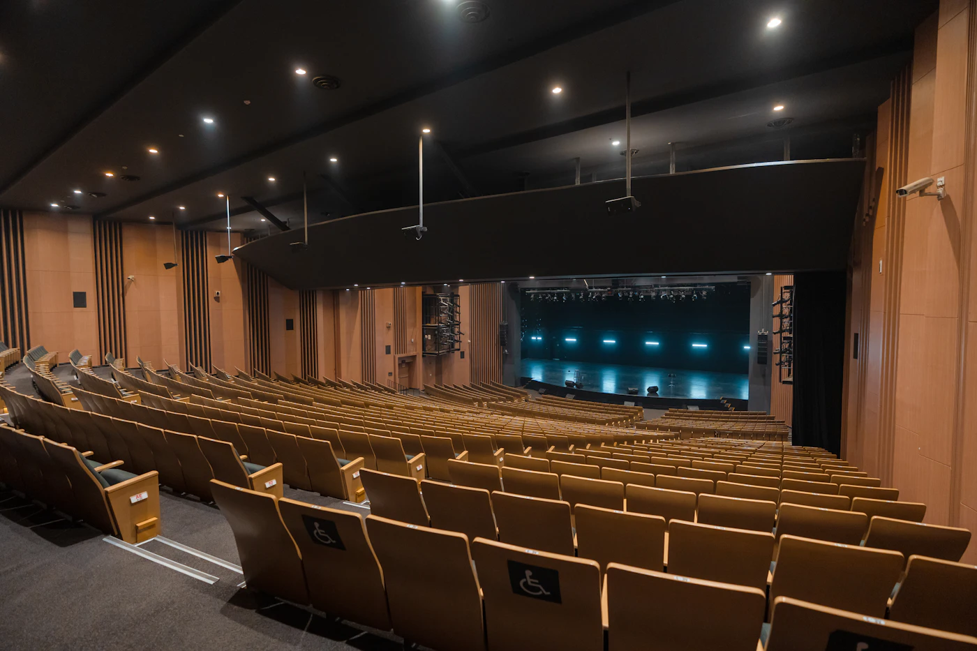Empty theater auditorium with rows of wooden seats