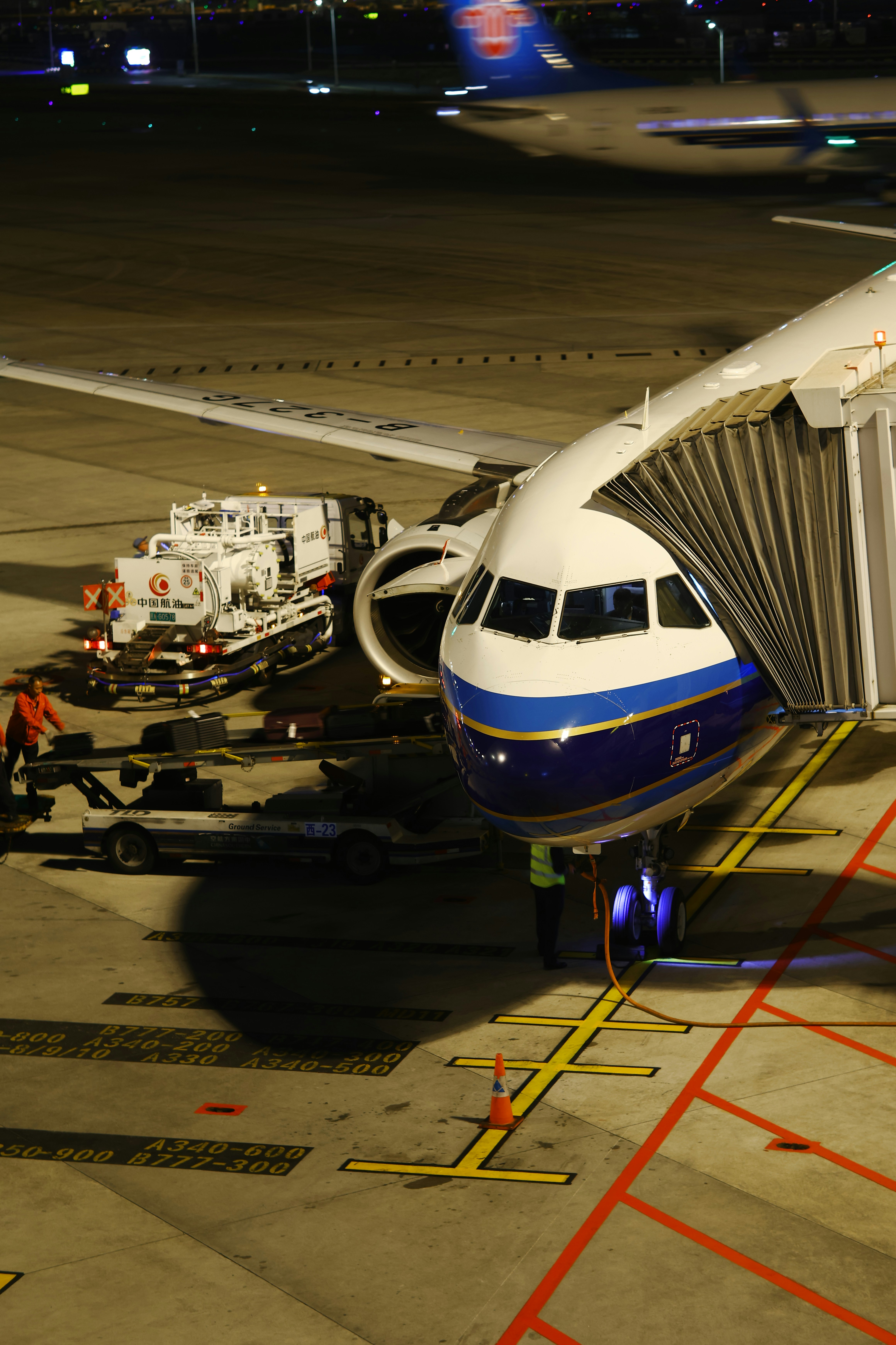 Airplane connected to a jet bridge at night